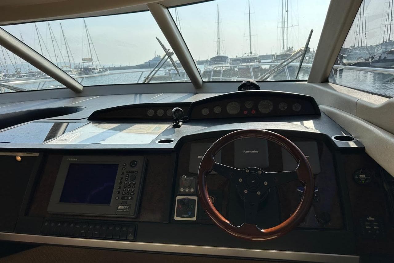 Helm of 2007 Princess 50 yacht with navigation equipment and marina view.