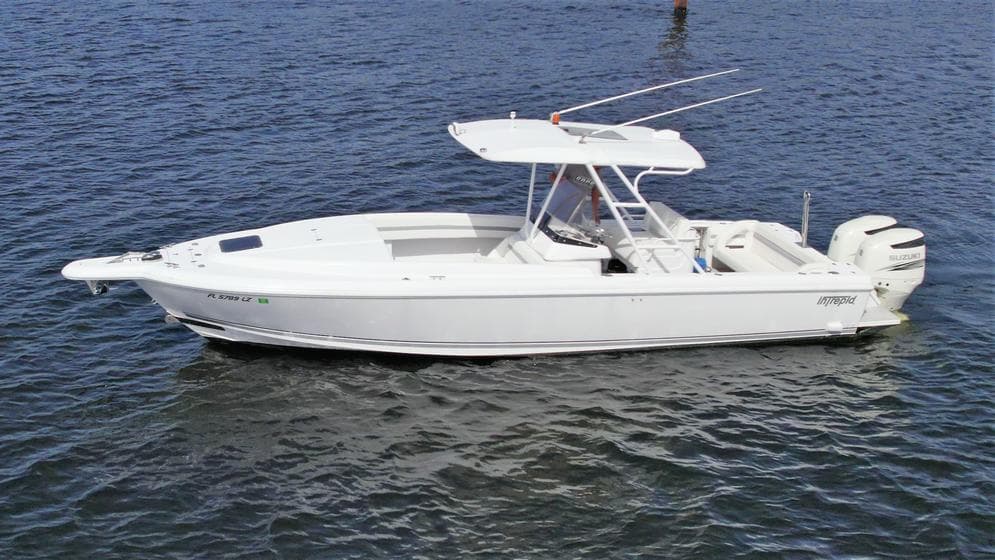 2003 Intrepid 32 boat on calm water, featuring a sleek white design and twin engines.