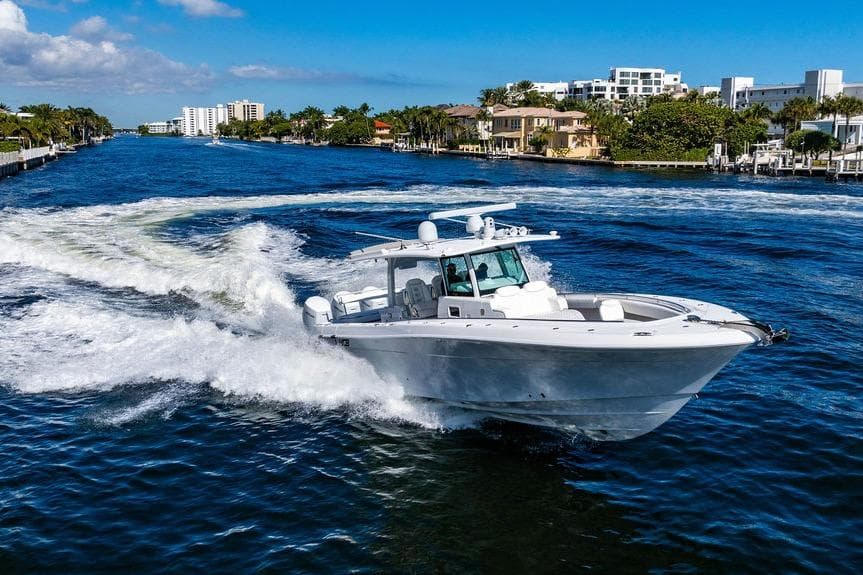 2024 HCB 42 Lujo cruising on a scenic waterway with luxury homes in the background.