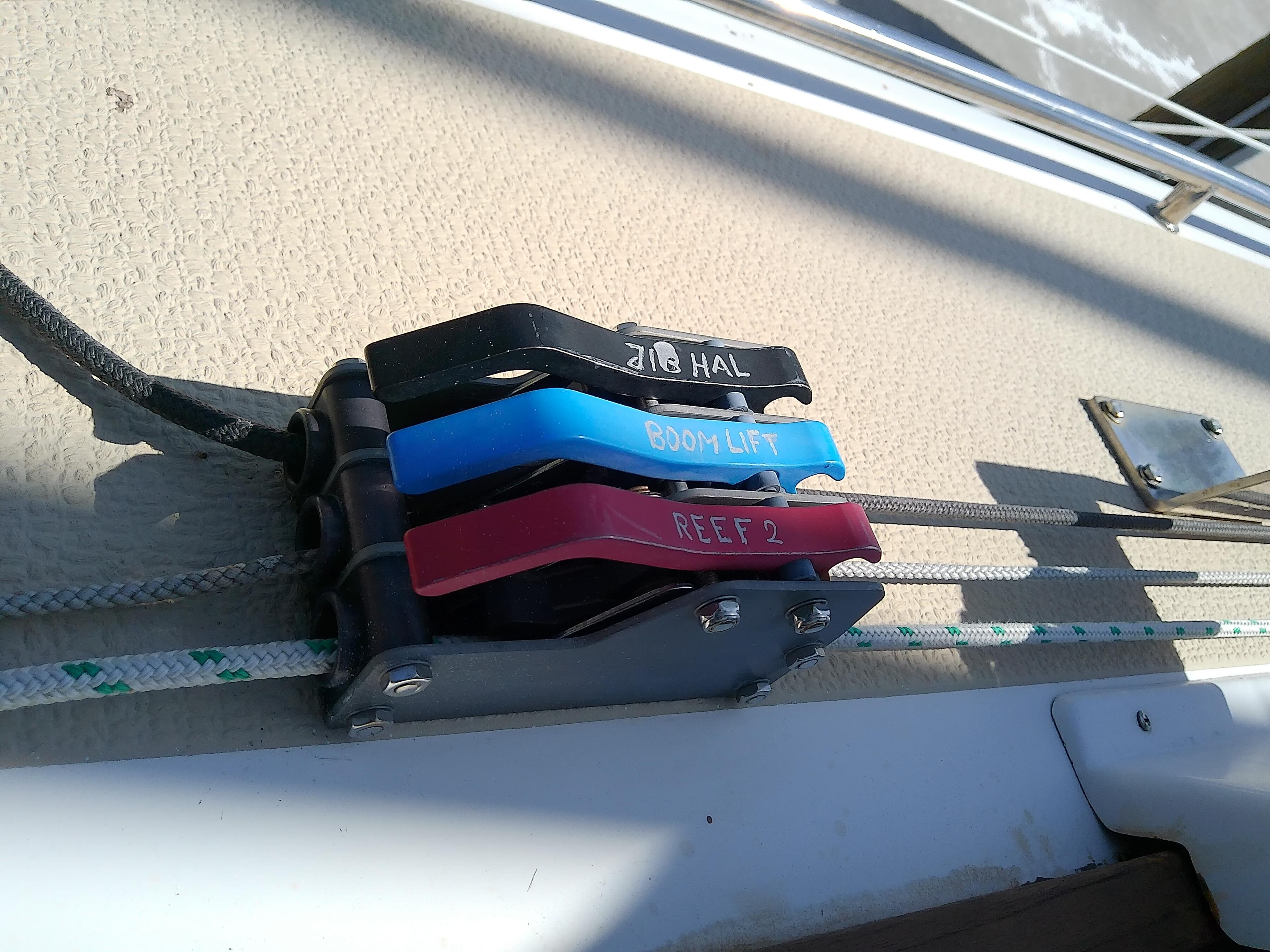 Com-Pac 27/3 sailboat control lines and clutches, 2017 model, featuring jib halyard, boom lift, and reef.