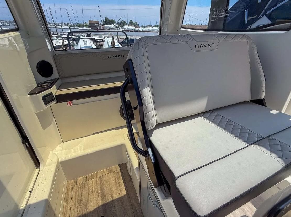 Interior of 2025 Navan C30 boat with cushioned seating and wood flooring.