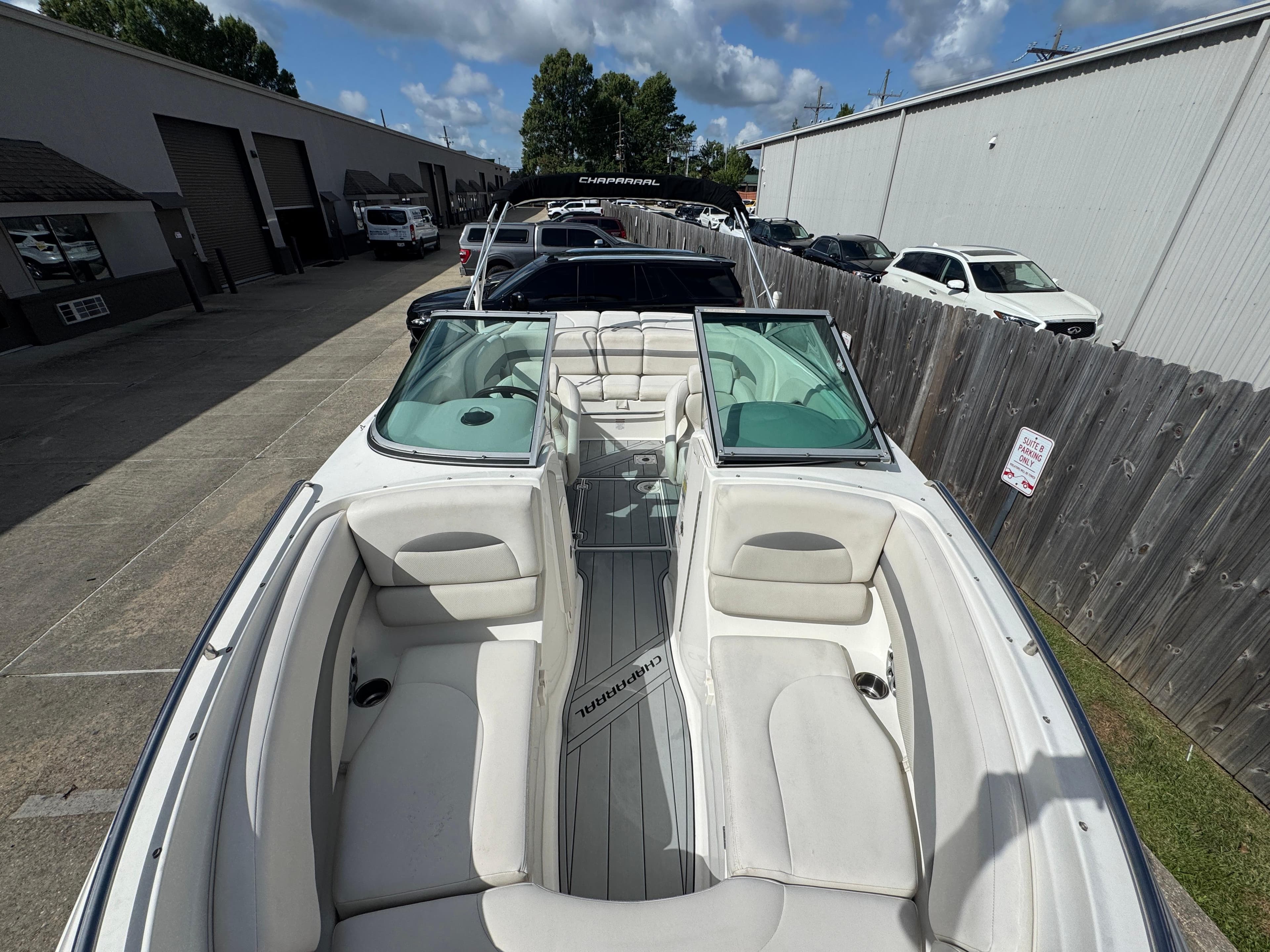 2006 Chaparral 236 SSi boat with white interior, parked outdoors on a sunny day.