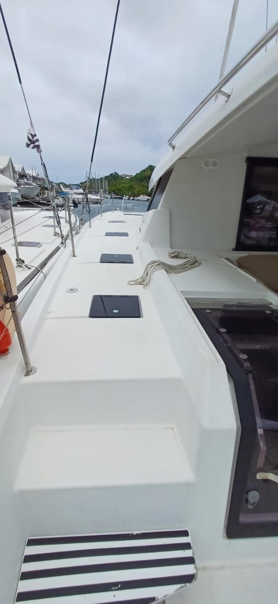 Fountaine Pajot Saona 47 catamaran deck, 2017 model, docked at marina under cloudy sky.