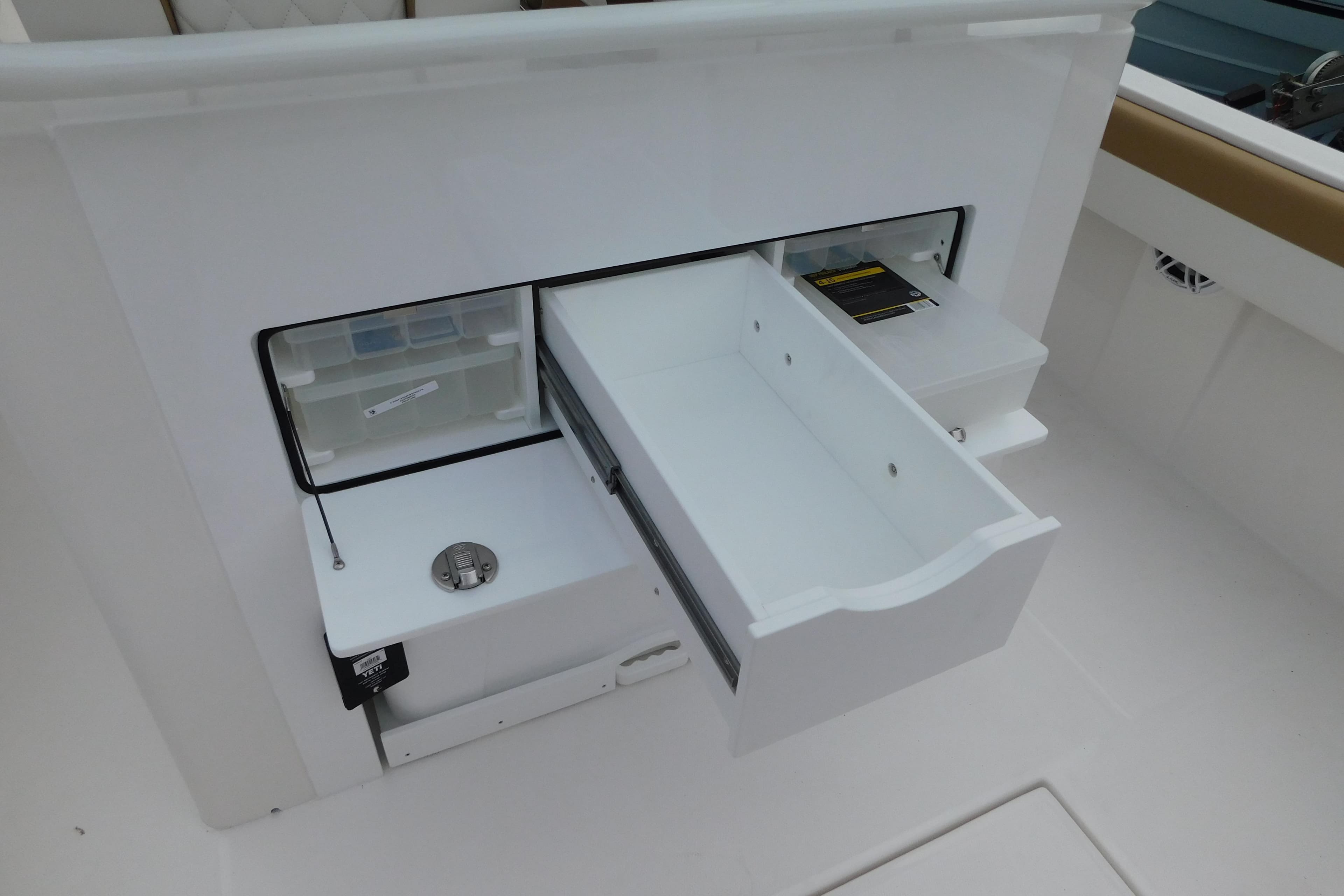 2026 Regulator 28 boat storage compartment with open drawers and tackle box.