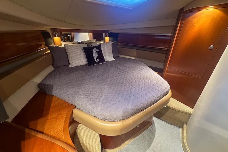 Luxurious cabin interior of 2005 Sea Ray 500 Sundancer yacht with cozy bedding.