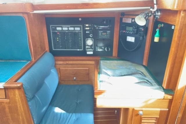 Navigation station of 2000 Gozzard 37 sailboat with control panel and seating.