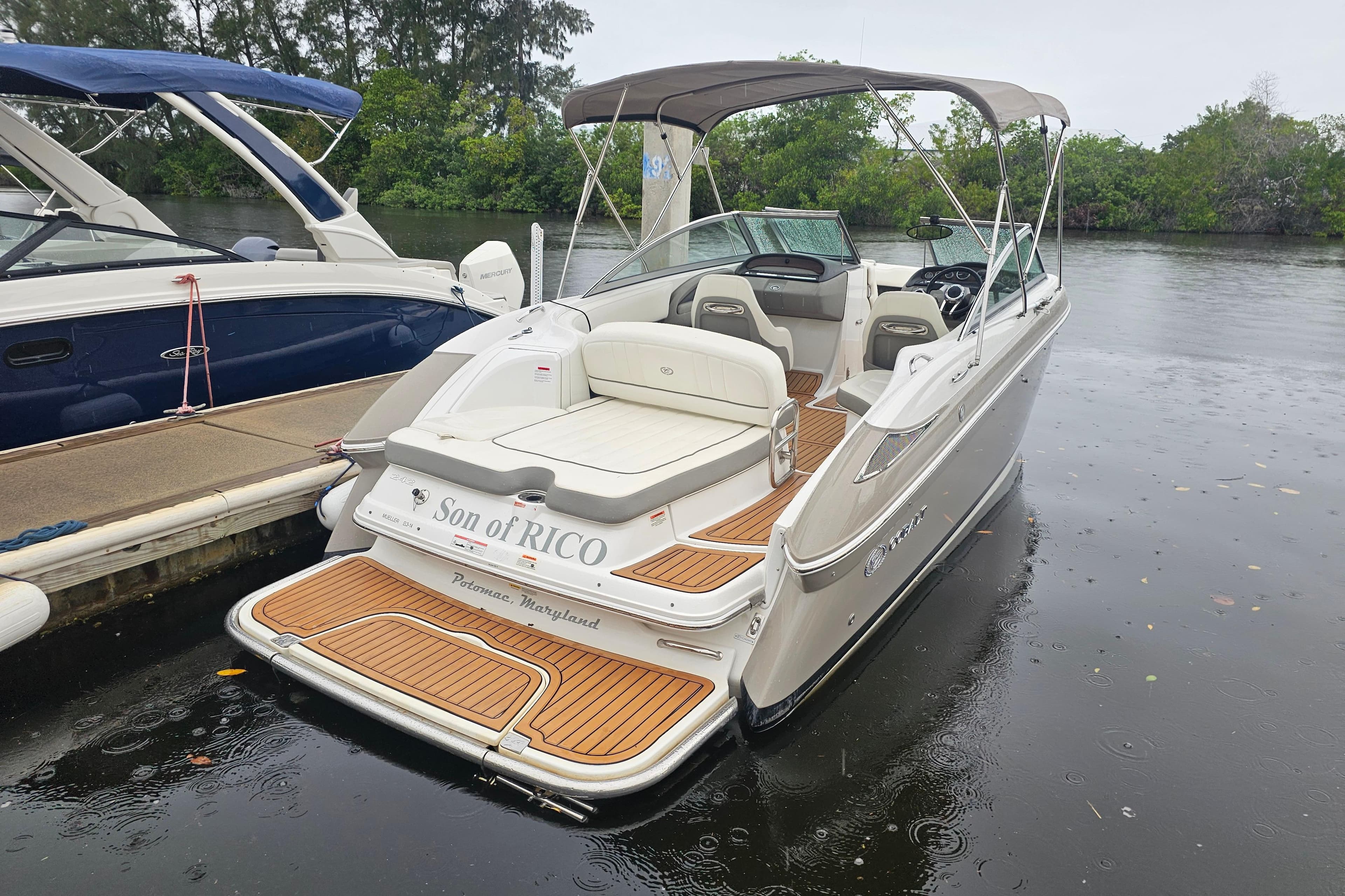 2012 Cobalt 242 boat docked on a rainy day, featuring a sleek design and spacious seating.