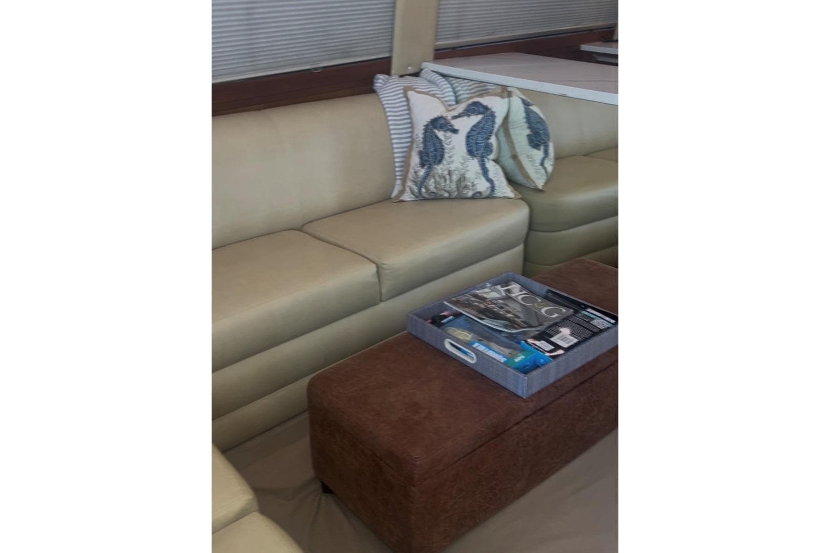 Luxurious interior of 1998 Ocean 53 Convertible yacht with beige seating and decorative pillows.