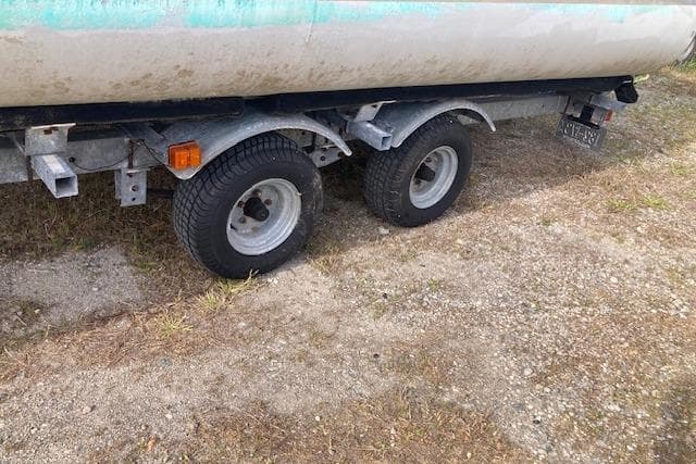 Trailer wheels of a 2010 Sweetwater Tuscany 2086 on a grassy surface.