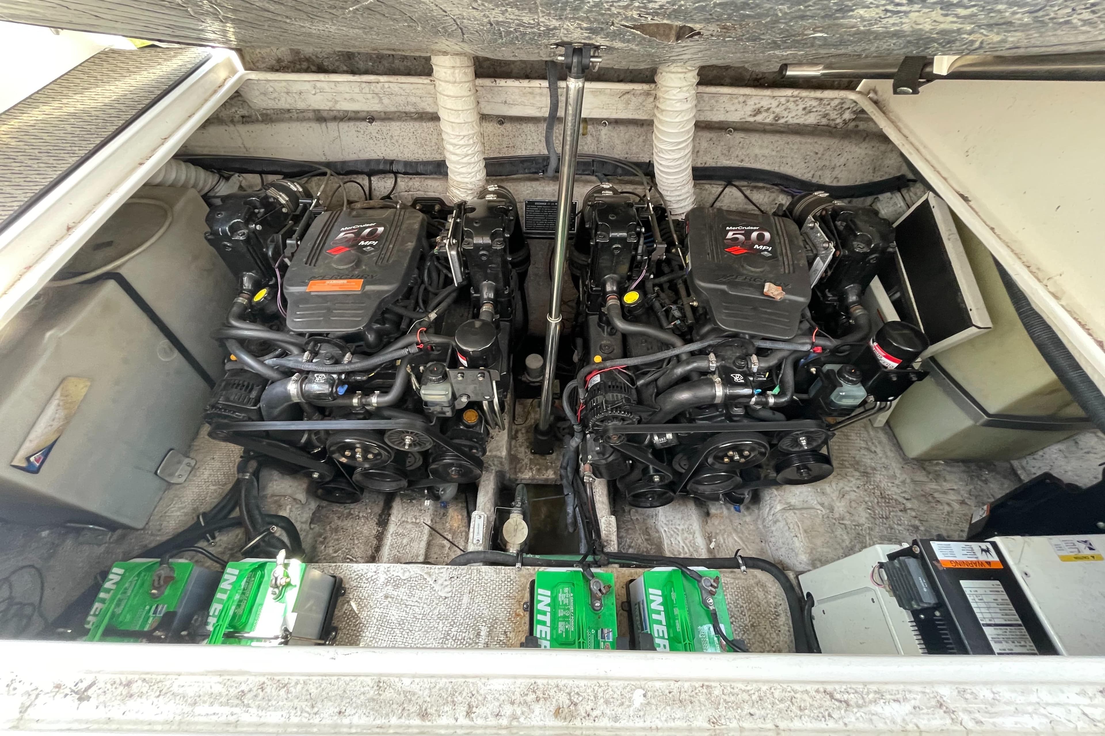 Engine compartment of a 2006 Rinker 320 Express Cruiser with dual engines and batteries.