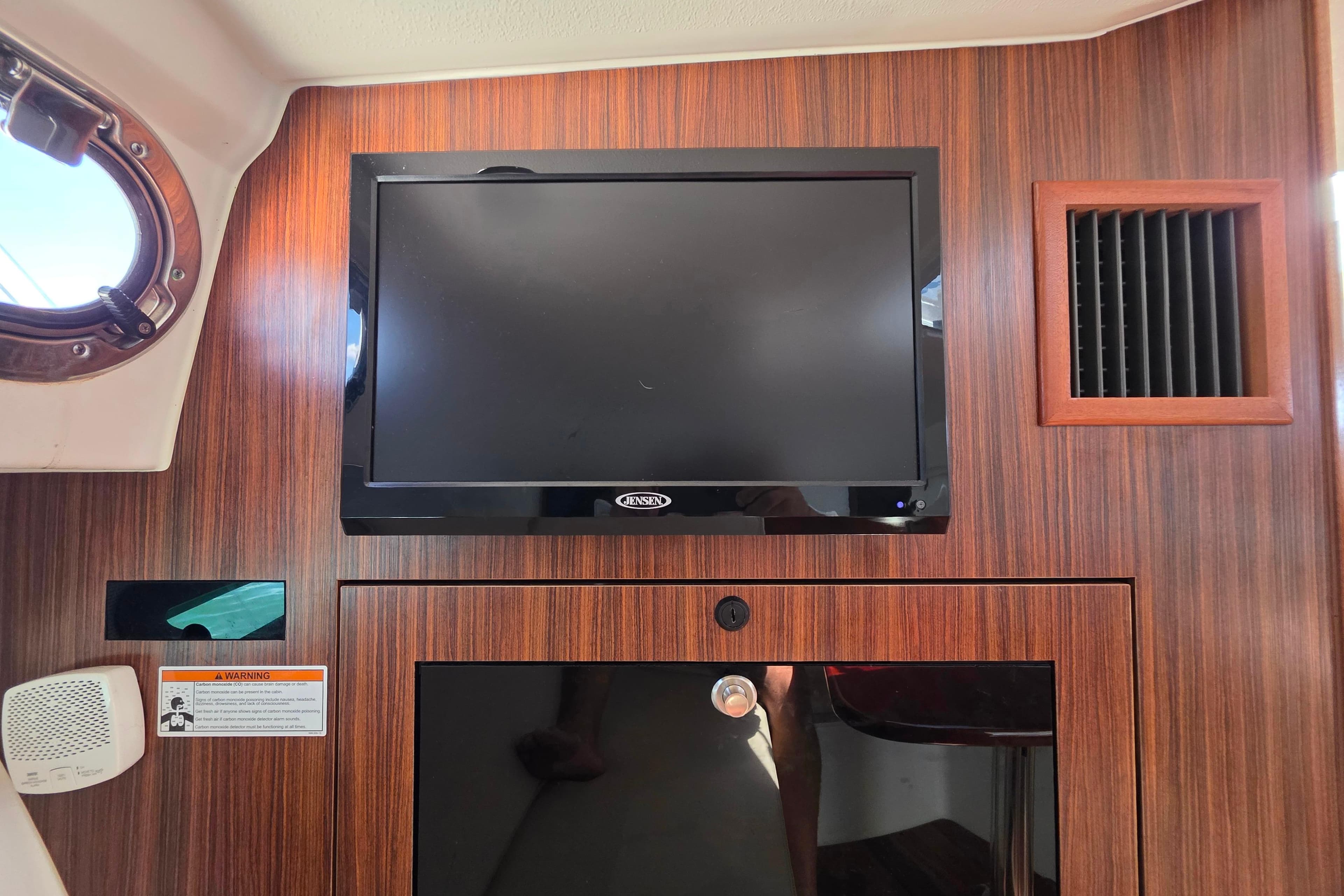 Interior of 2020 Pursuit OS 325 Offshore with wall-mounted Jensen TV.