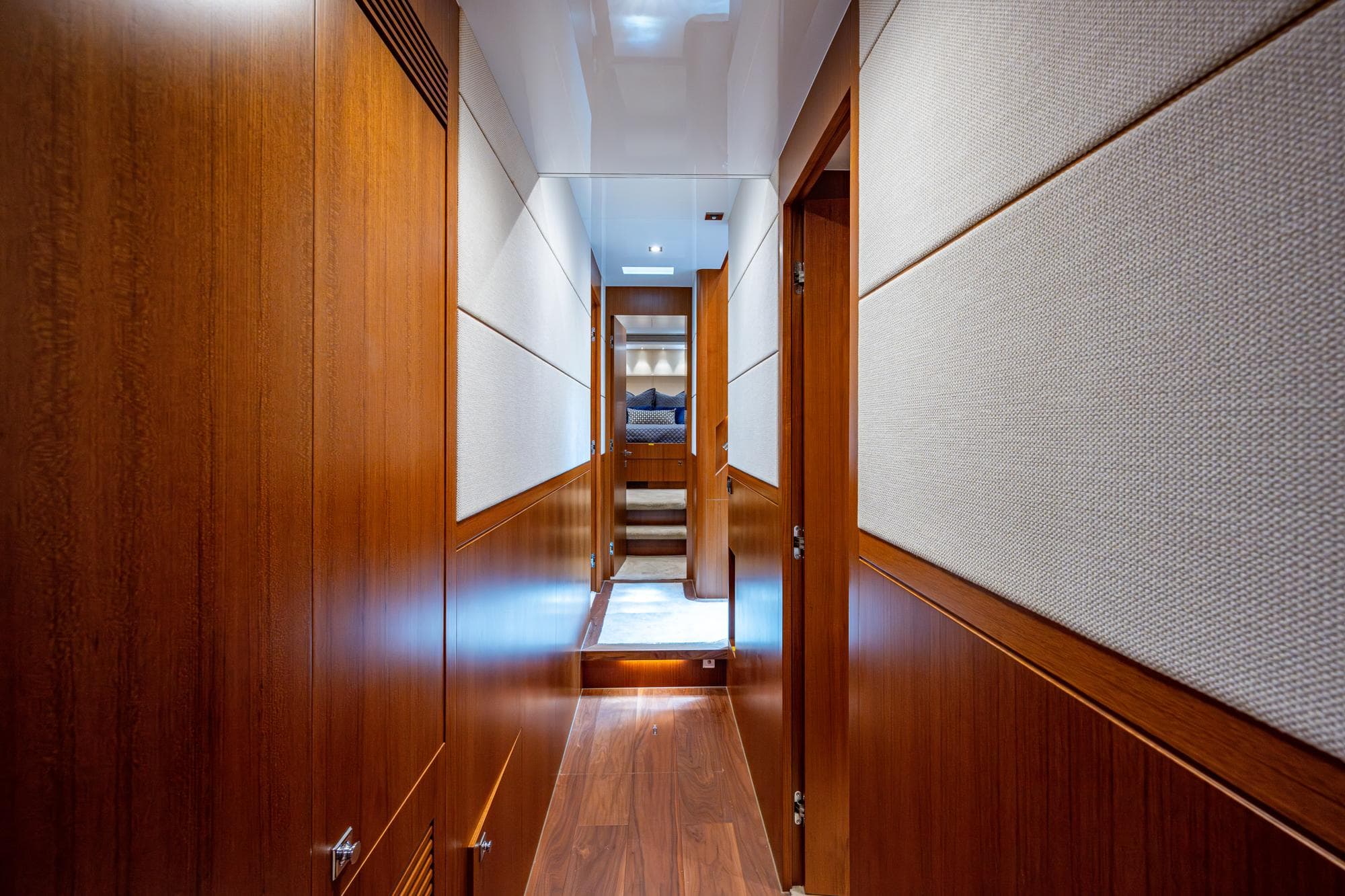 Luxurious hallway inside 2016 Horizon E88 yacht with wooden paneling and modern design.