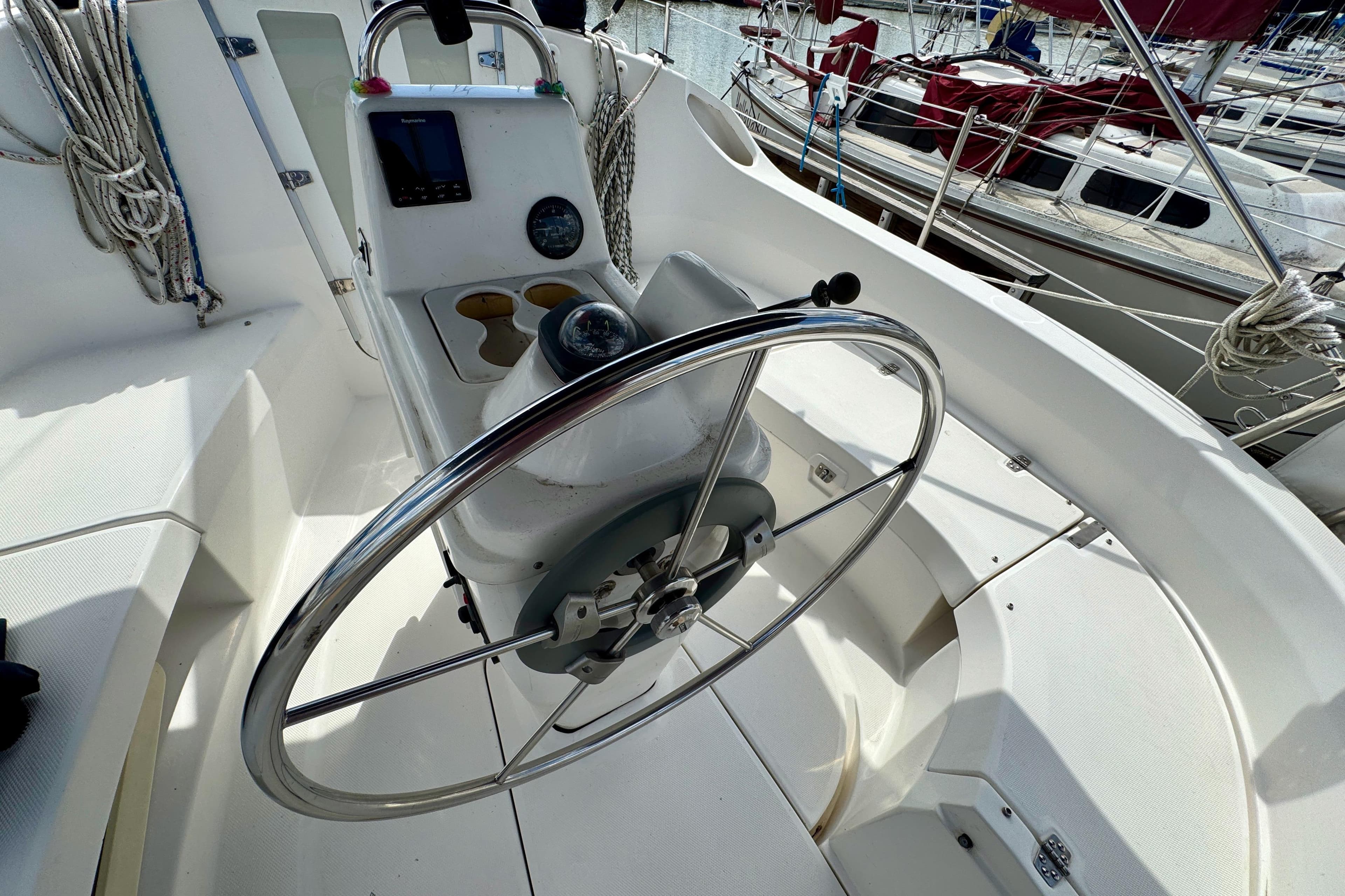 Cockpit of 2001 Hunter 320 sailboat with steering wheel and navigation instruments.