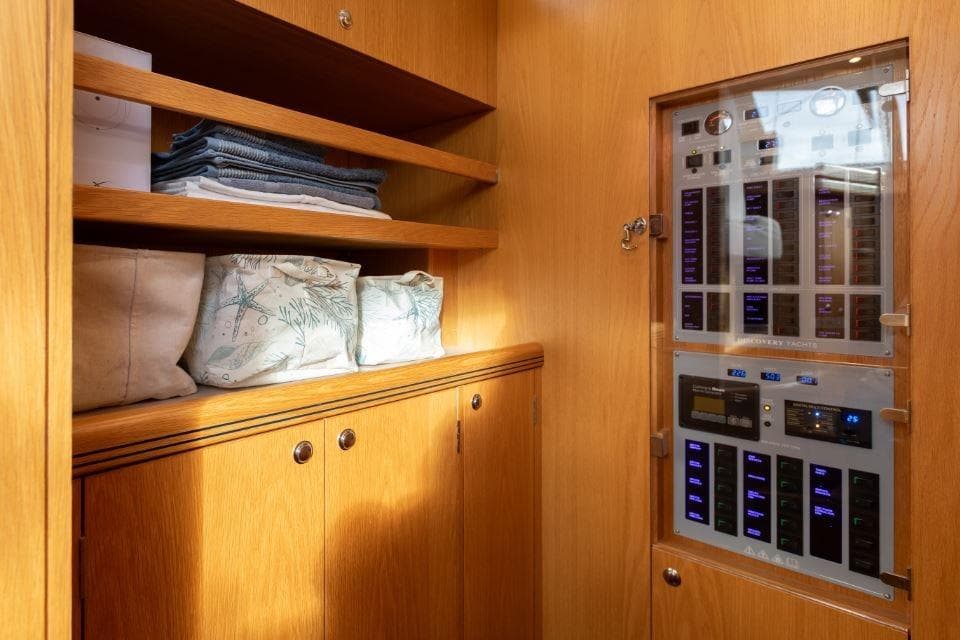 Interior of 2015 Discovery 58 yacht with wooden cabinetry and control panel.