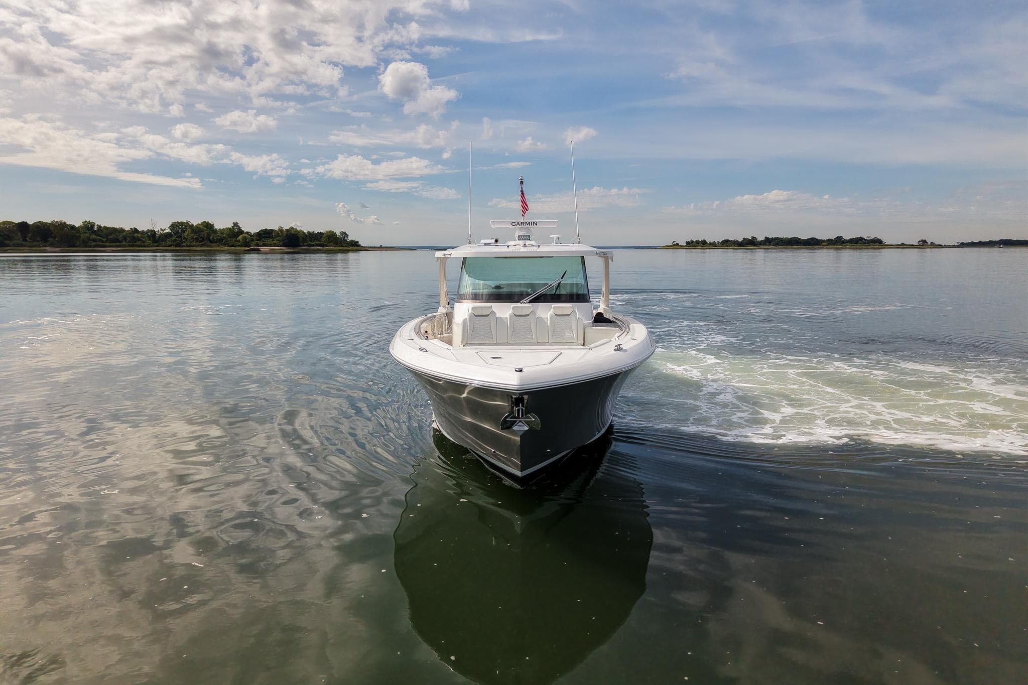 2025 Tiara Yachts 43 LS cruising on calm waters under a partly cloudy sky.