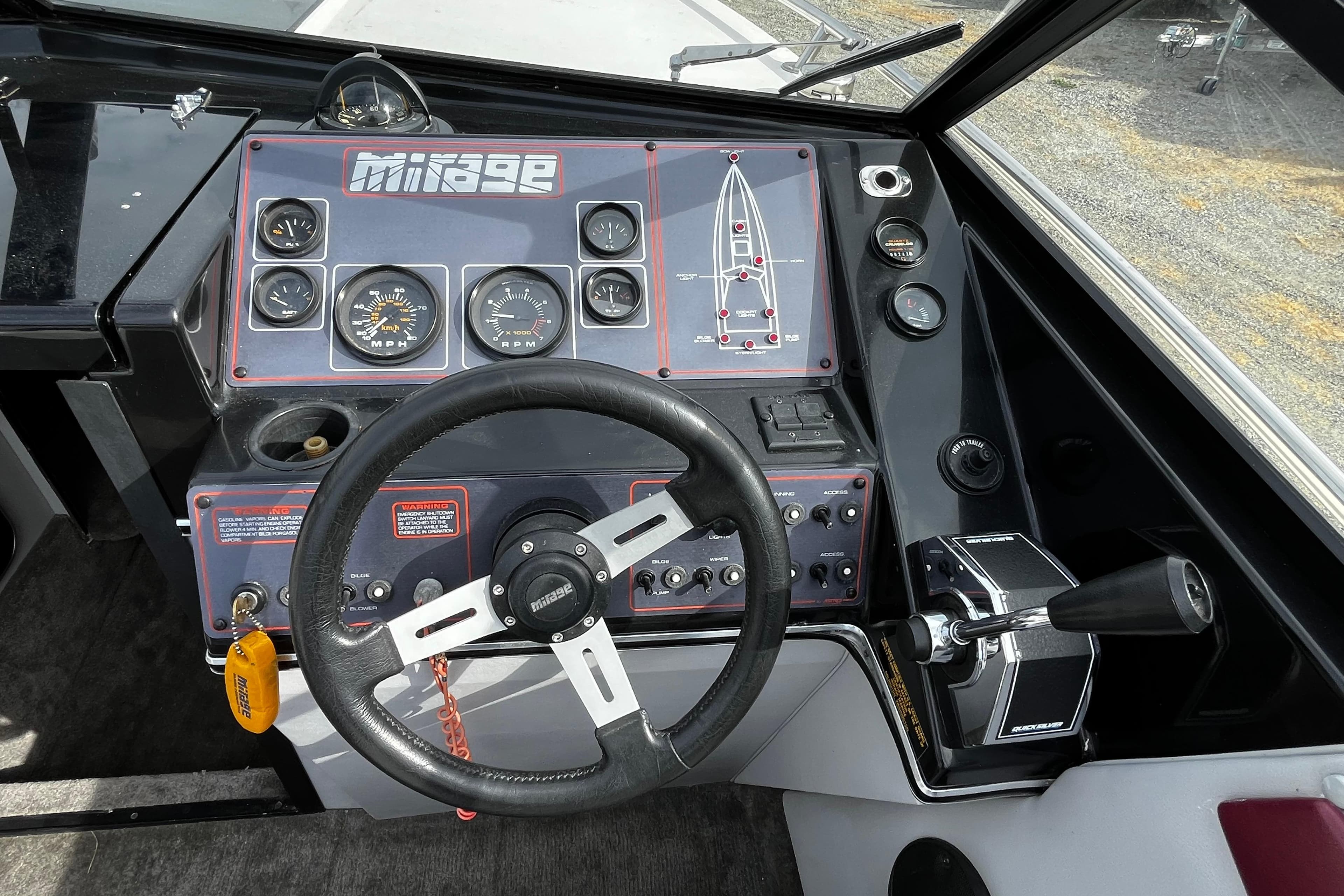 1988 Mirage Manufacturing 217 Intruder boat dashboard with steering wheel and control panel.