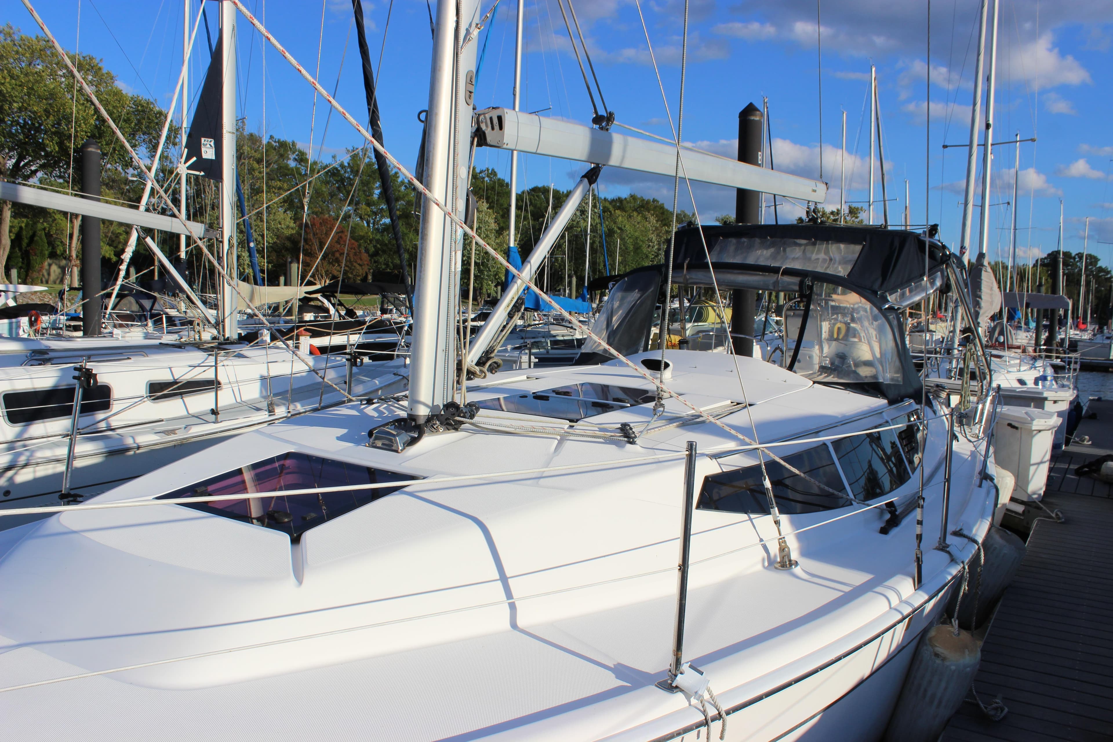 2014 Hunter 33 sailboat docked at marina under clear blue sky.
