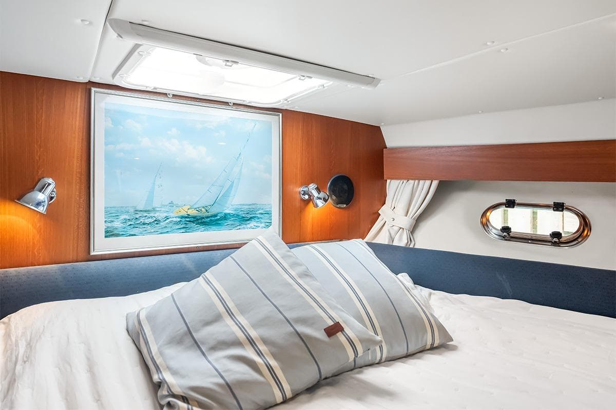 Cozy cabin interior of 2000 Nimbus 380 Carisma with nautical decor and soft lighting.