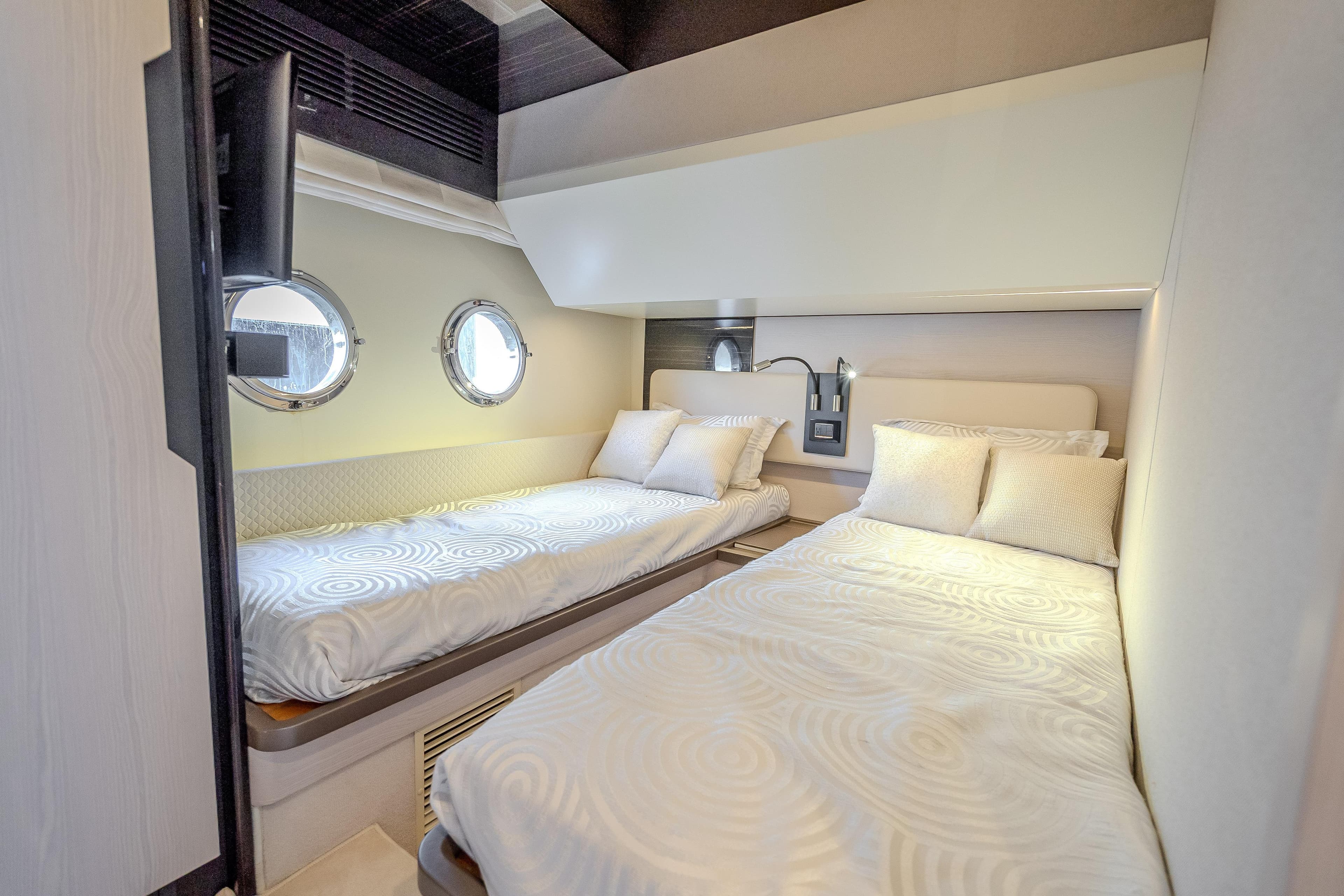 Luxurious 2019 Azimut 66 yacht cabin with twin beds and porthole windows.