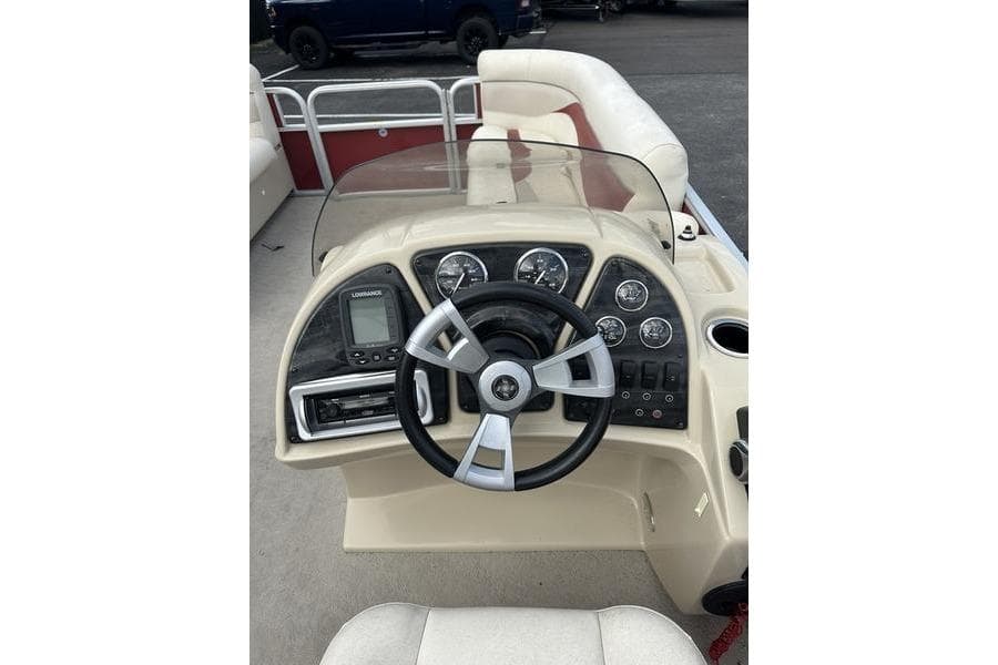 Steering console of 2014 Godfrey Sweetwater 2086 C pontoon boat with gauges and controls.