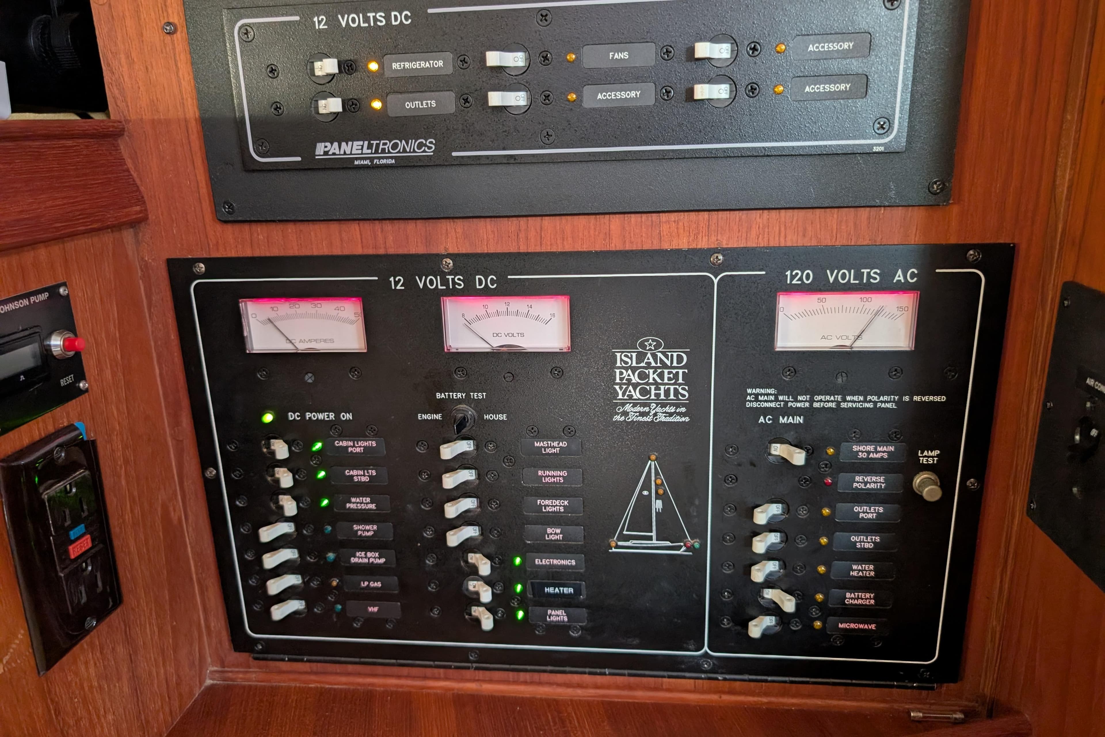 Electrical control panel on a 1999 Island Packet 320 yacht, featuring DC and AC voltage meters.