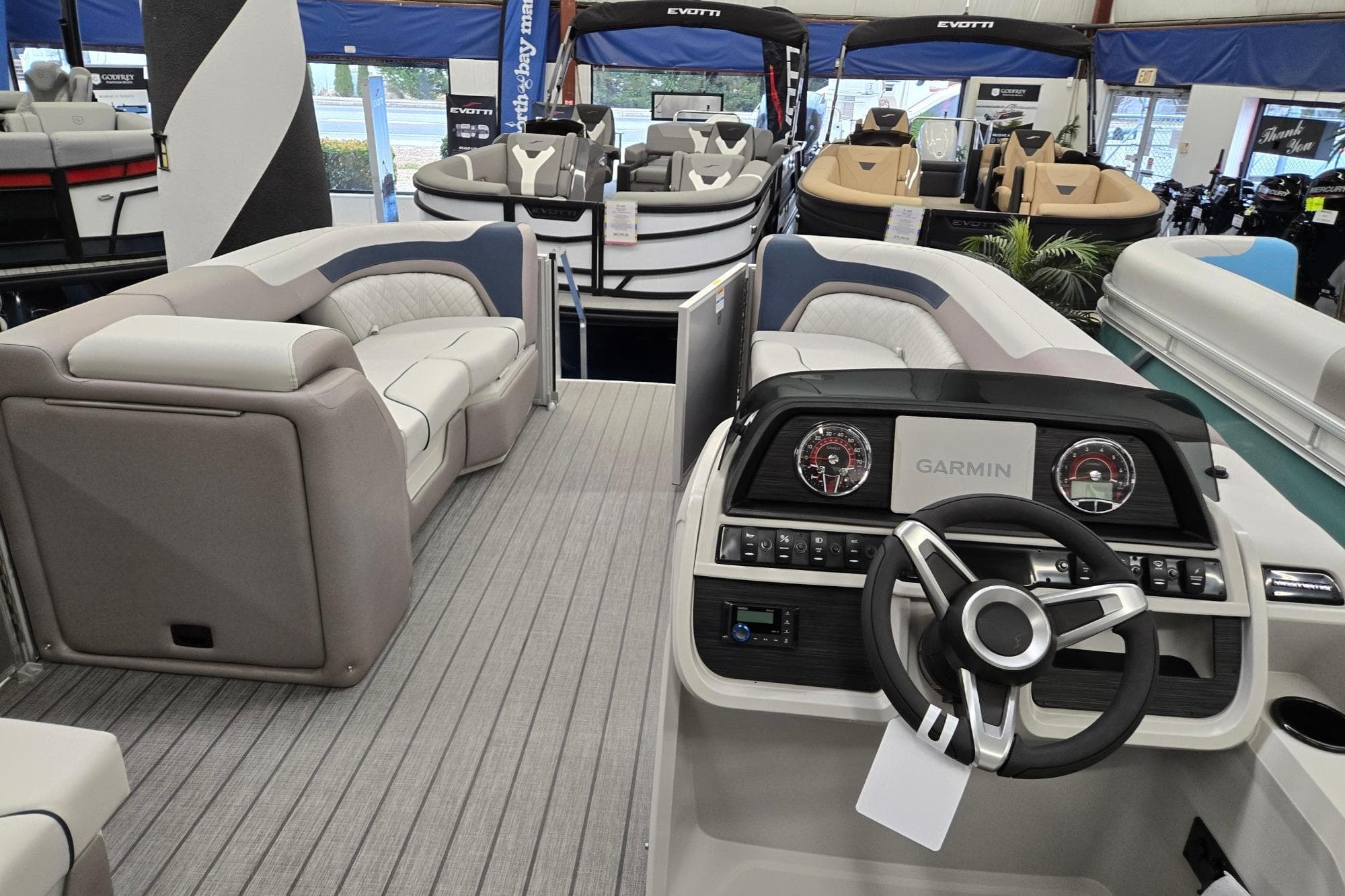 2026 Godfrey Sweetwater 2286 FS pontoon boat interior with Garmin dashboard and plush seating.
