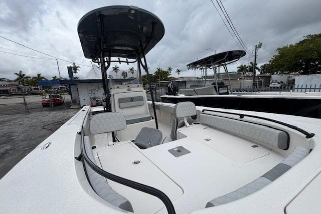 2026 Carolina Skiff 24 Ultra Elite boat with spacious deck and seating, under cloudy skies.