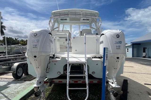 2023 World Cat 325 DC boat with dual Yamaha 300 V6 engines, docked outdoors.