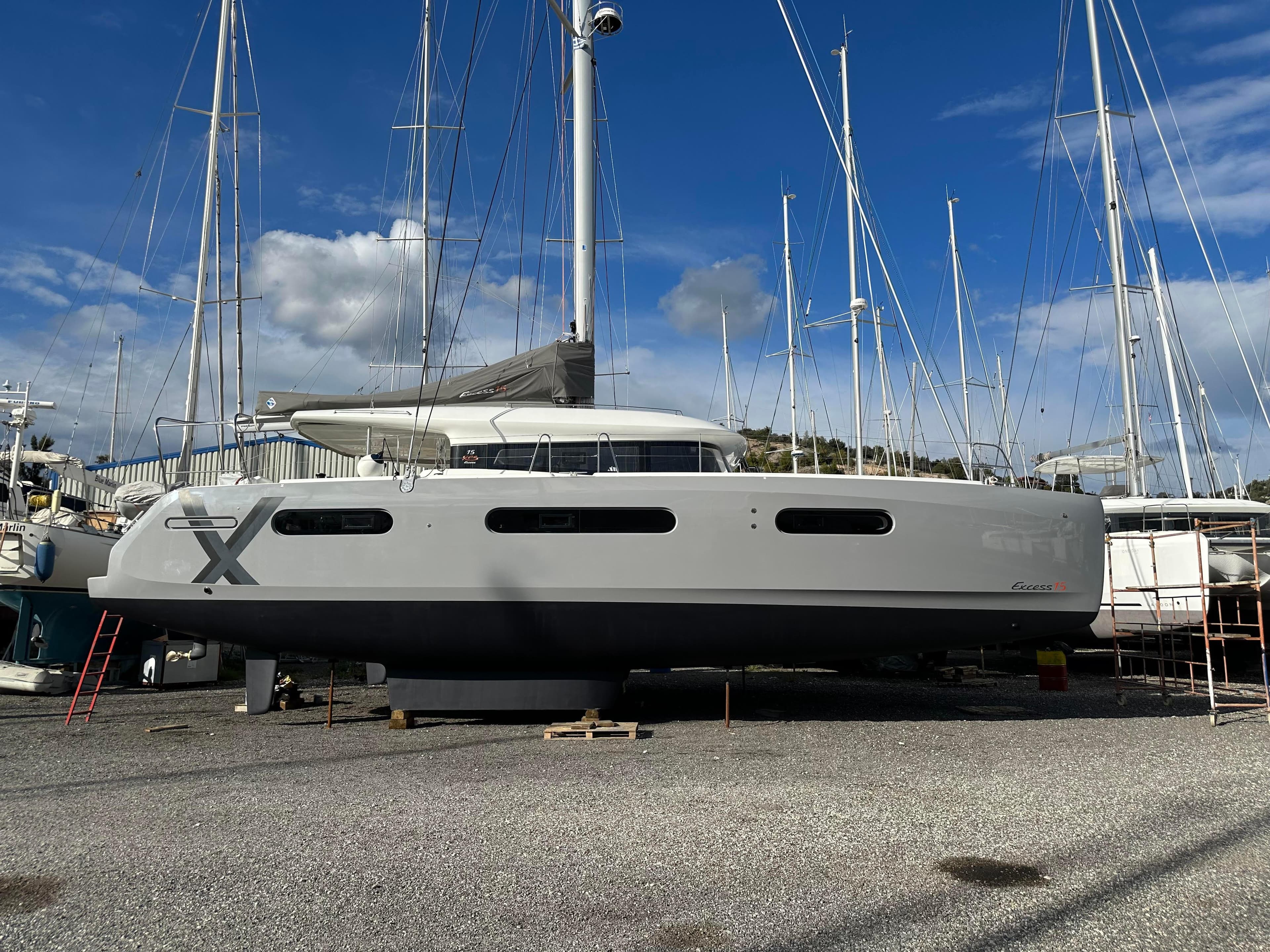 2023 Excess 15 catamaran on dry dock with blue sky background.