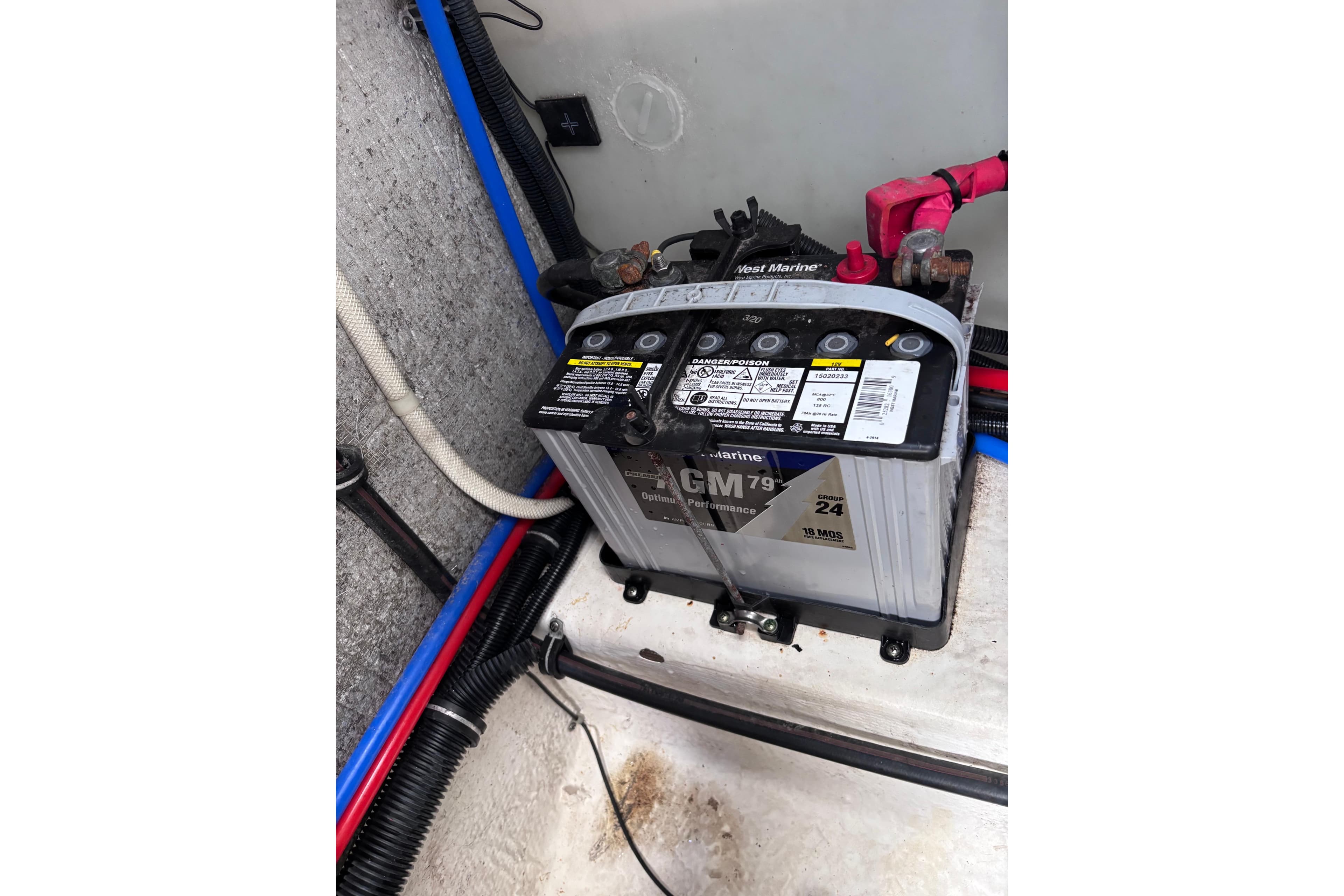 Battery compartment of a 2007 Rinker EX 370 boat, featuring a marine battery.
