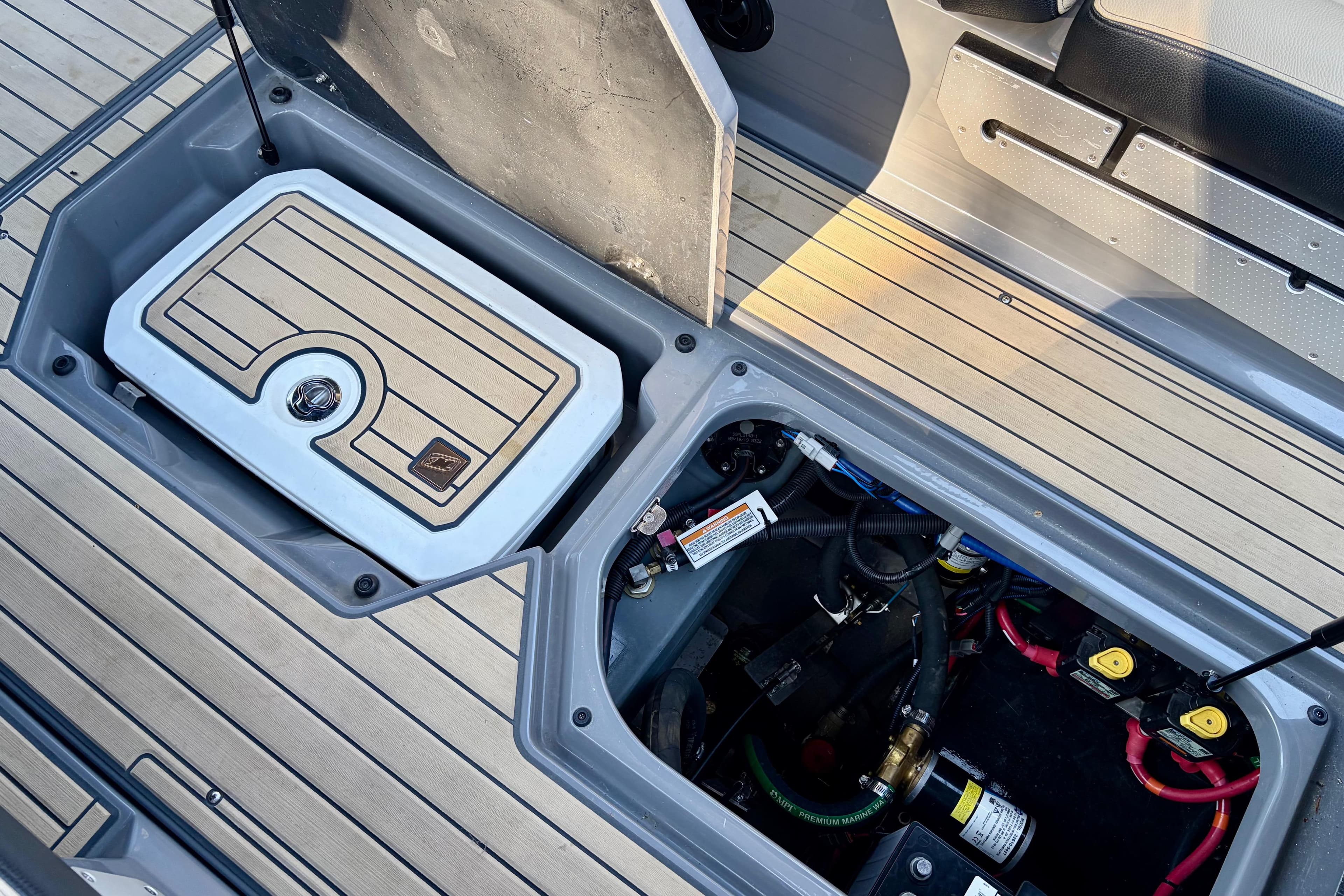 2020 Nautique Super Air Nautique G23 Paragon engine compartment with open storage hatch.