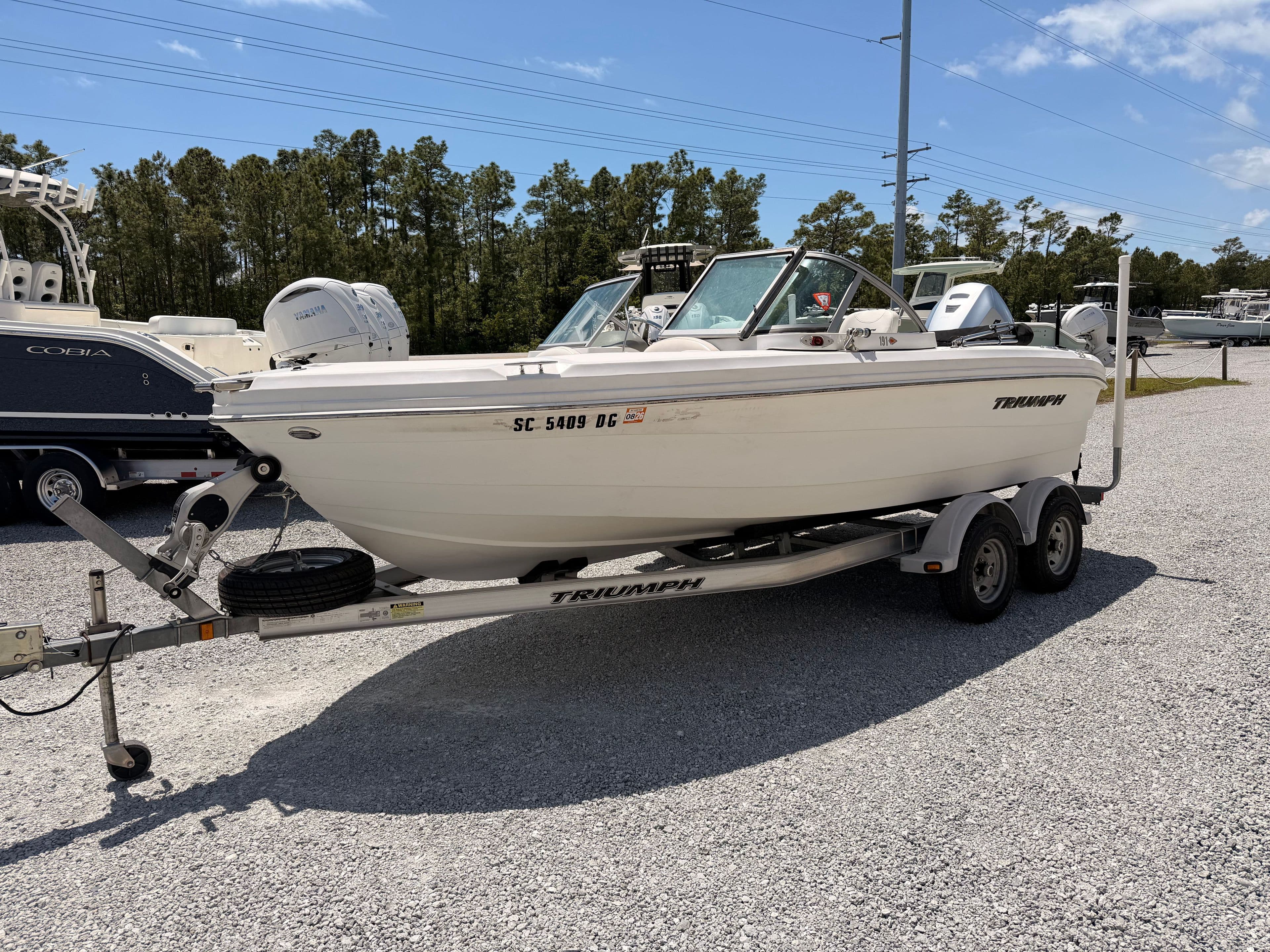 2011 Triumph 191 FS boat parked on trailer outdoors.