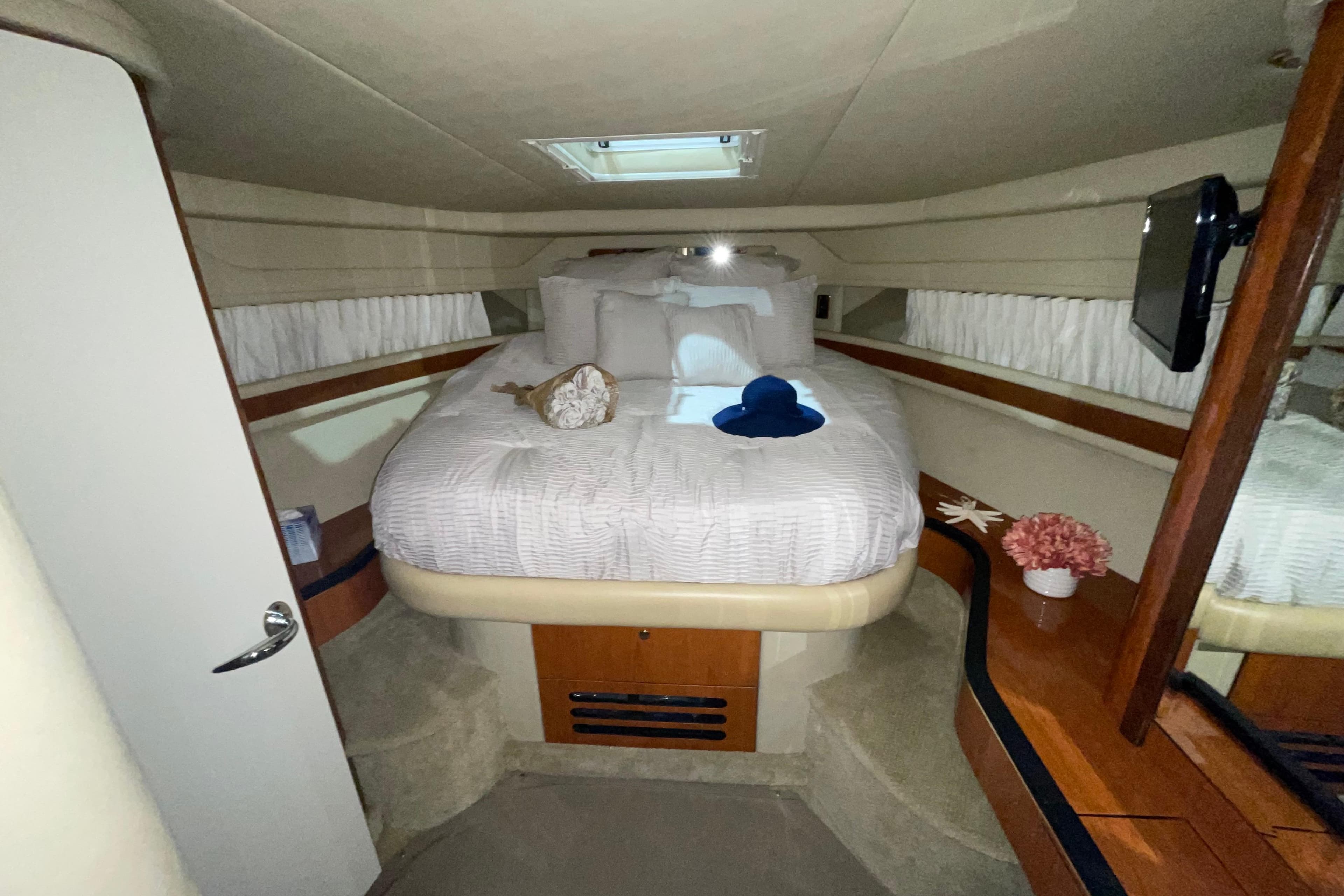 Luxurious cabin interior of 2001 Sea Ray Sundancer 460 yacht with cozy bed and decor.