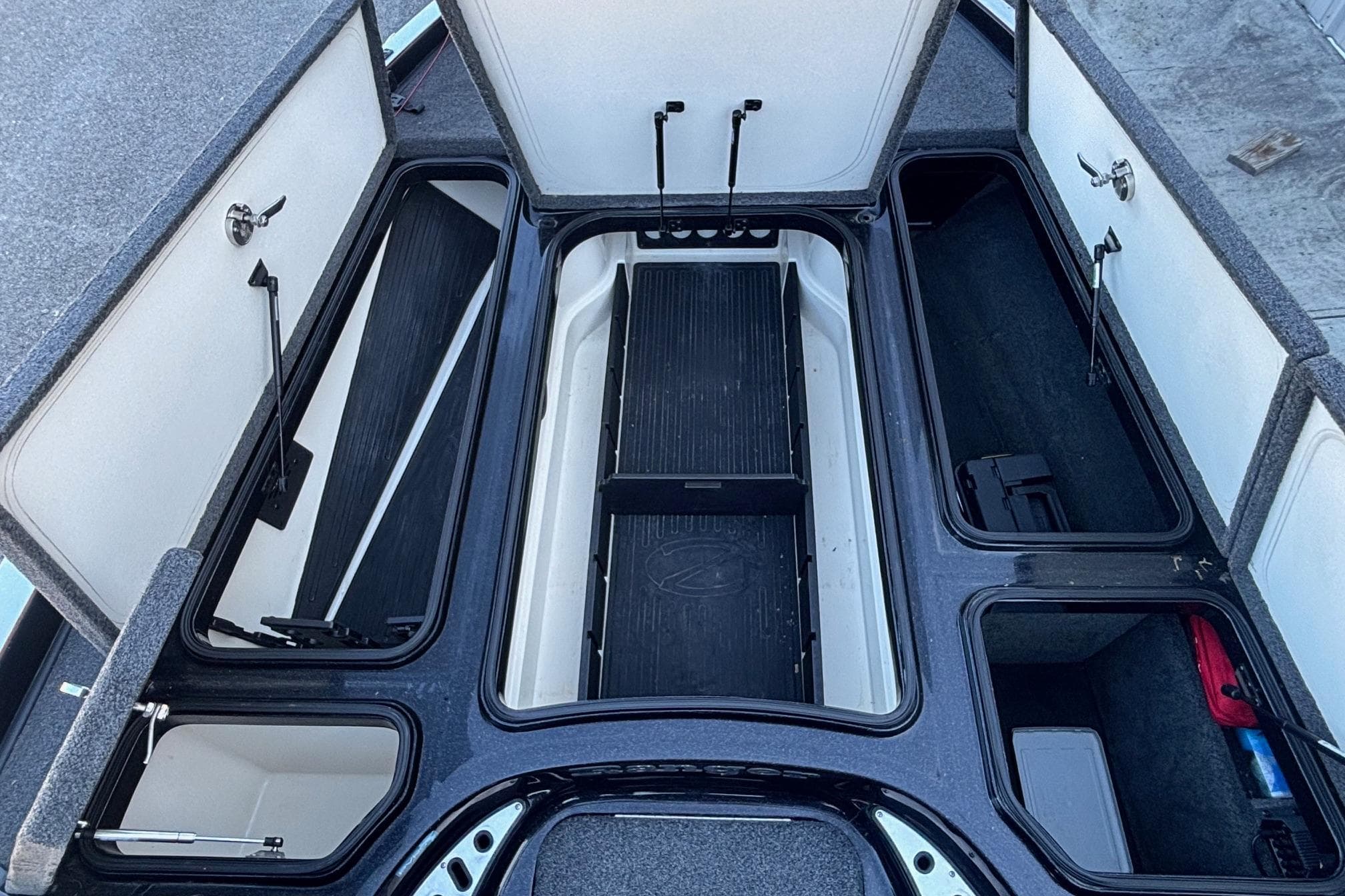 2017 Ranger Z521 Comanche boat storage compartments open, showcasing organized interior layout.