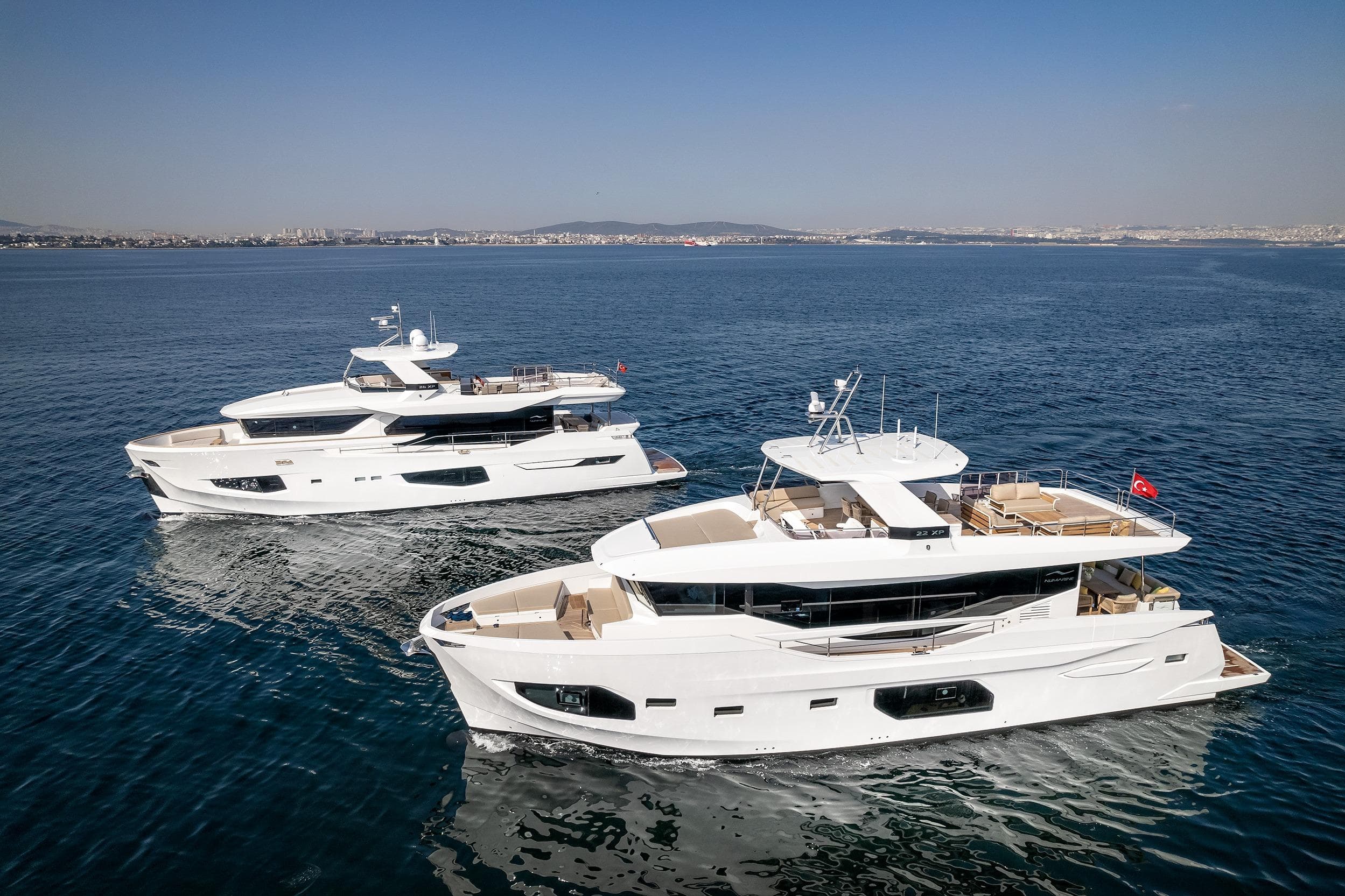 Two luxurious 2025 Numarine 22XP yachts cruising on open water.