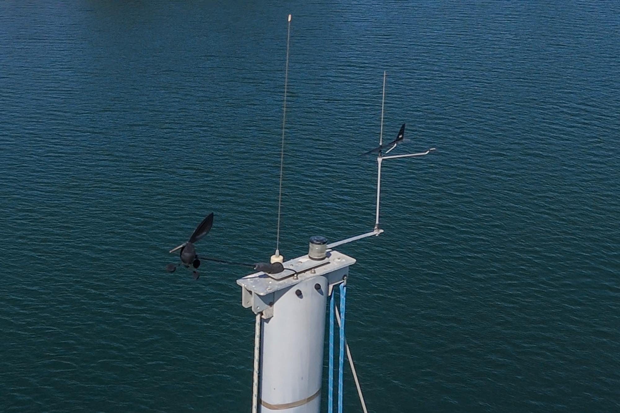 Mast of 2004 Lagoon 380 catamaran with birds flying over calm water.