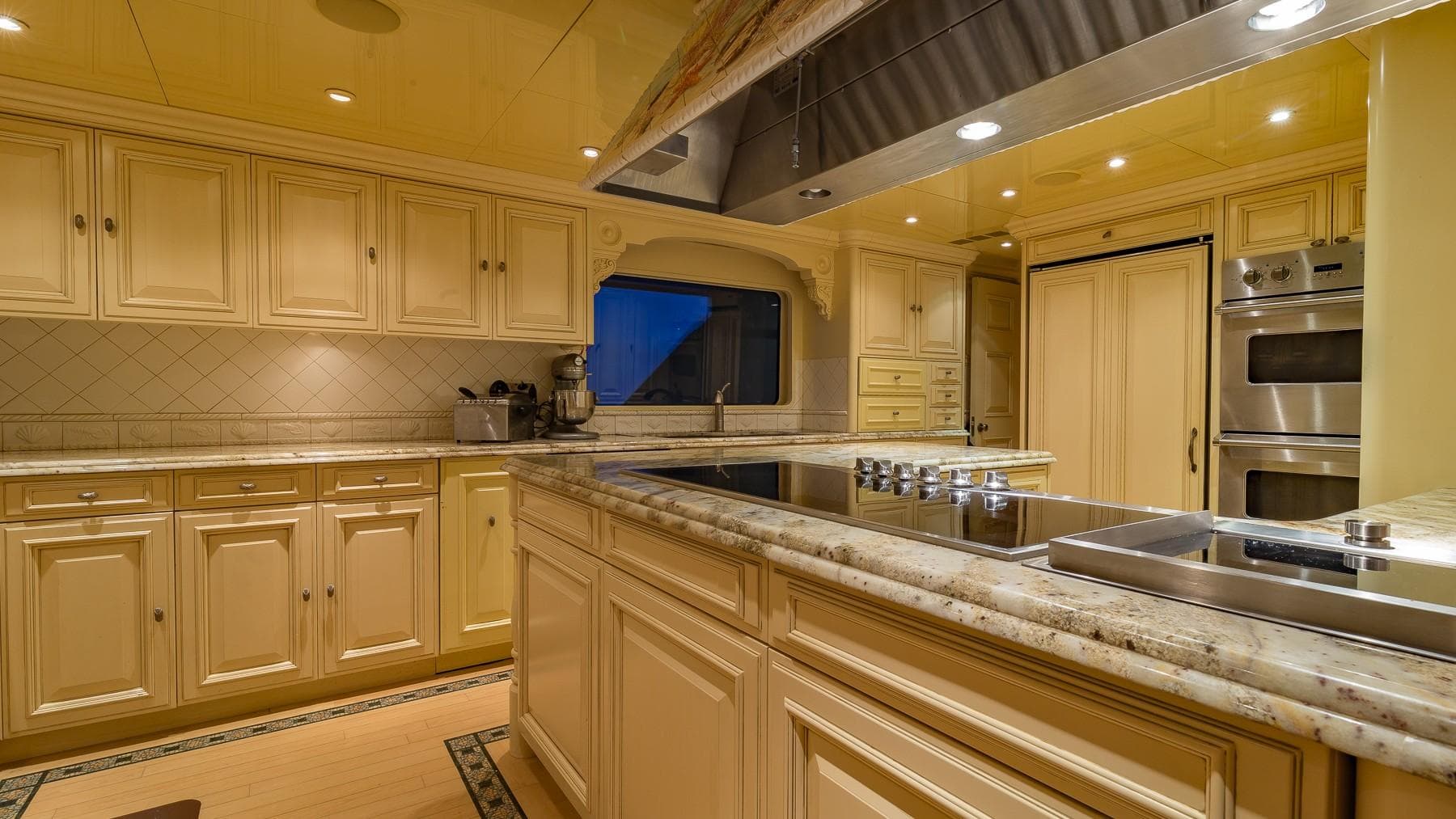 Luxurious kitchen on 2002 Christensen Tri Deck yacht with elegant cabinetry and modern appliances.
