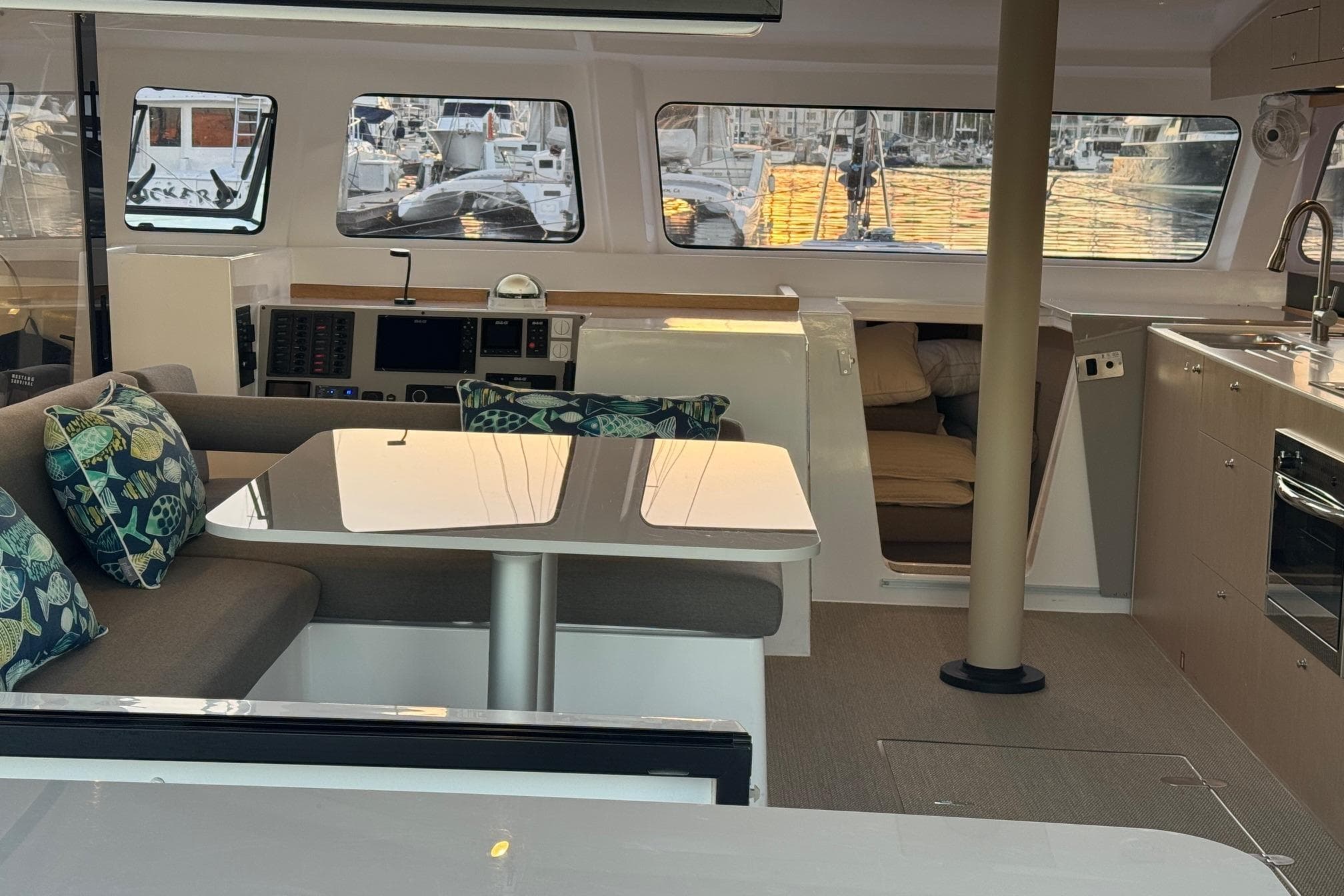 Interior of 2023 NEEL 43 yacht with modern seating, table, and kitchen area.