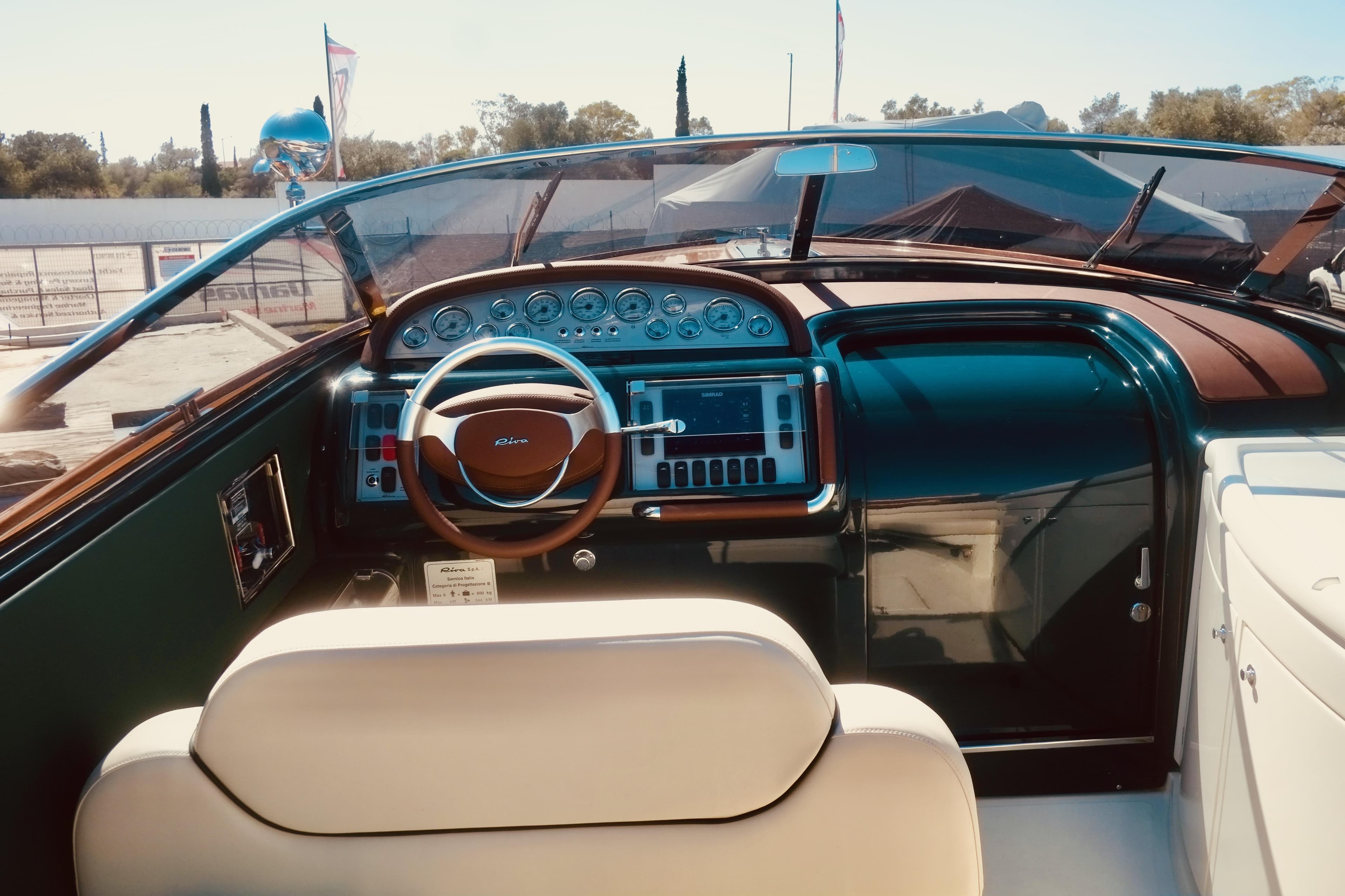 Interior view of a 2003 Riva Aquariva 33 boat, featuring a classic wooden dashboard and steering wheel.