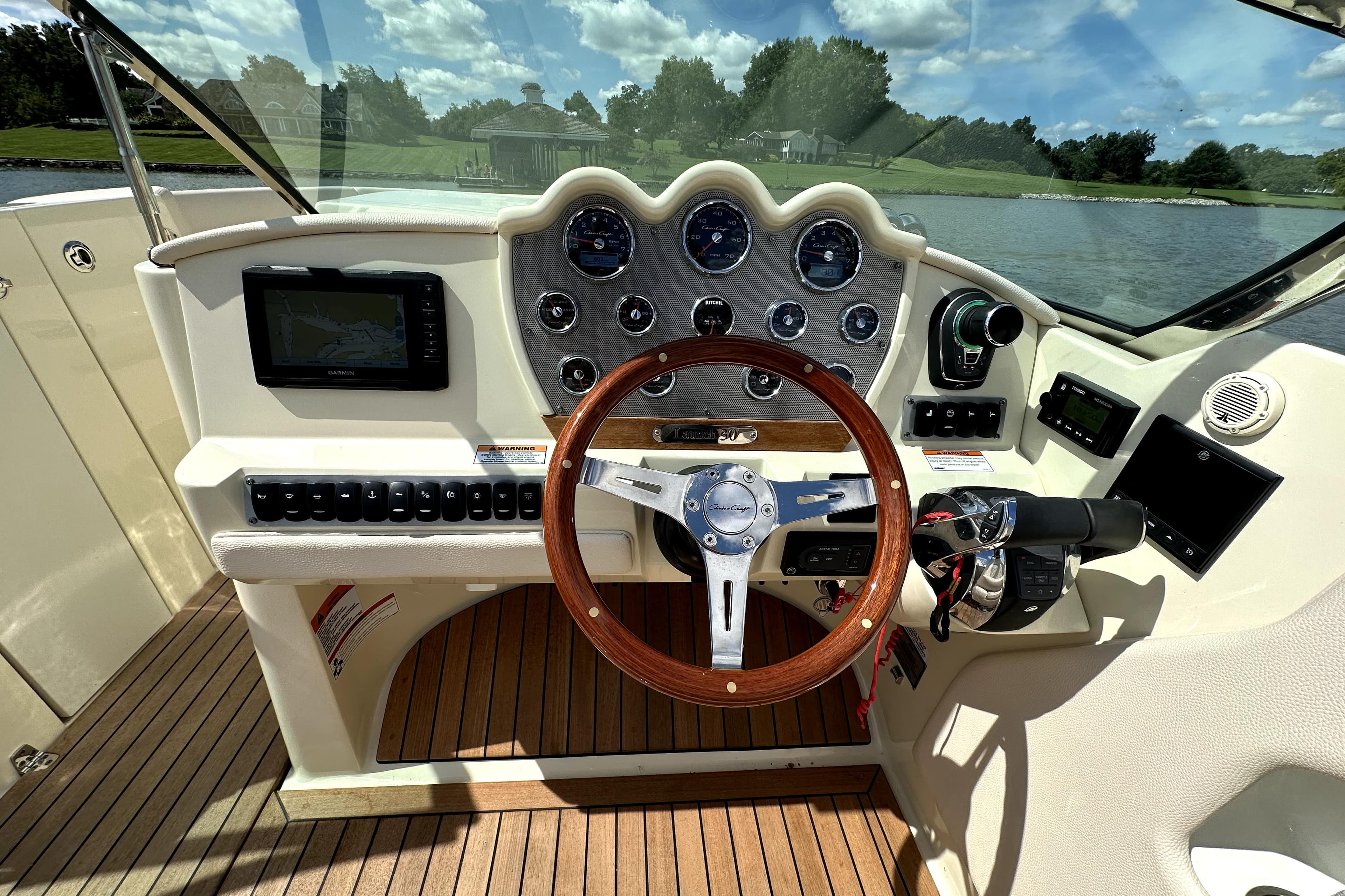 2019 Chris-Craft Launch 30 dashboard with wooden steering wheel and navigation system.