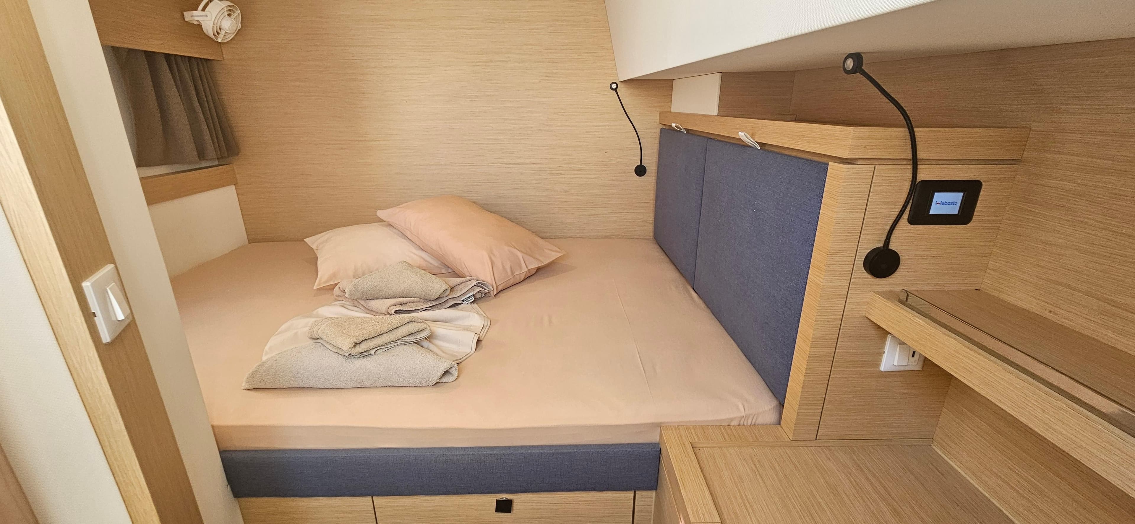 Cozy cabin interior of 2024 Fountaine Pajot Tanna 47 with modern bedding and wood accents.