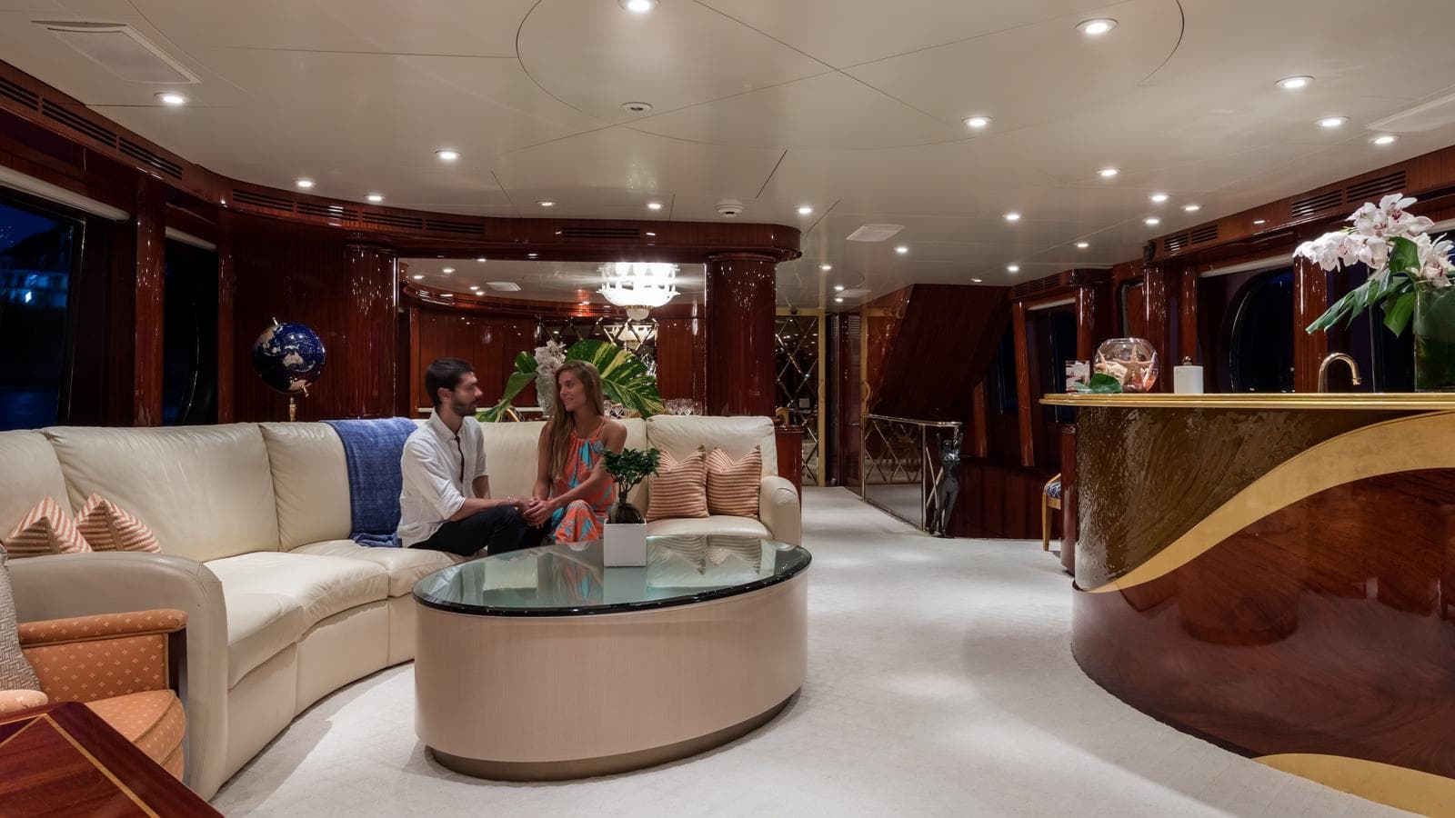 Luxurious yacht interior with elegant seating, glass table, and stylish bar, Custom Louisbourg 2004 model.
