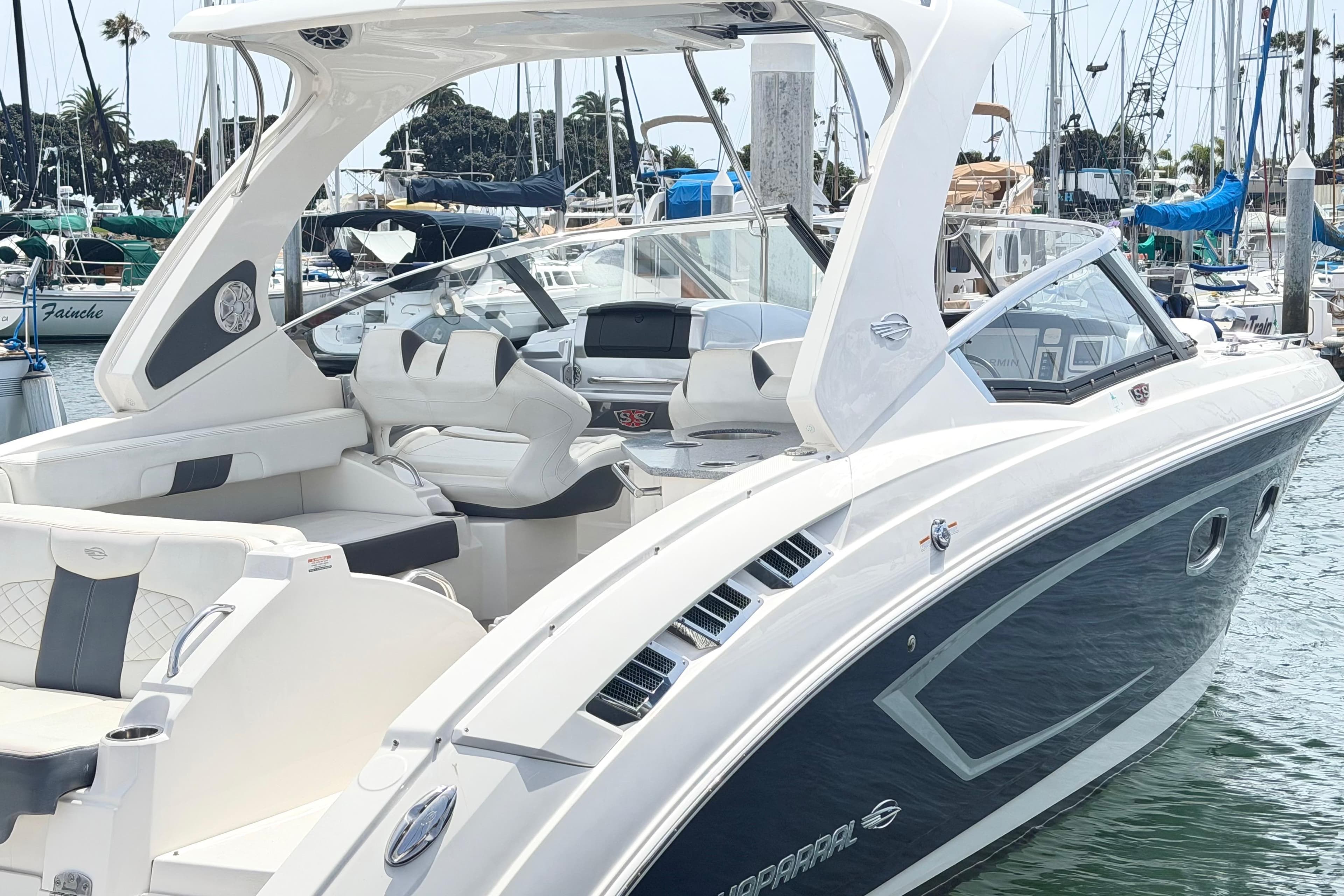 2014 Chaparral 327 SSX boat docked in a marina, featuring sleek design and luxurious seating.