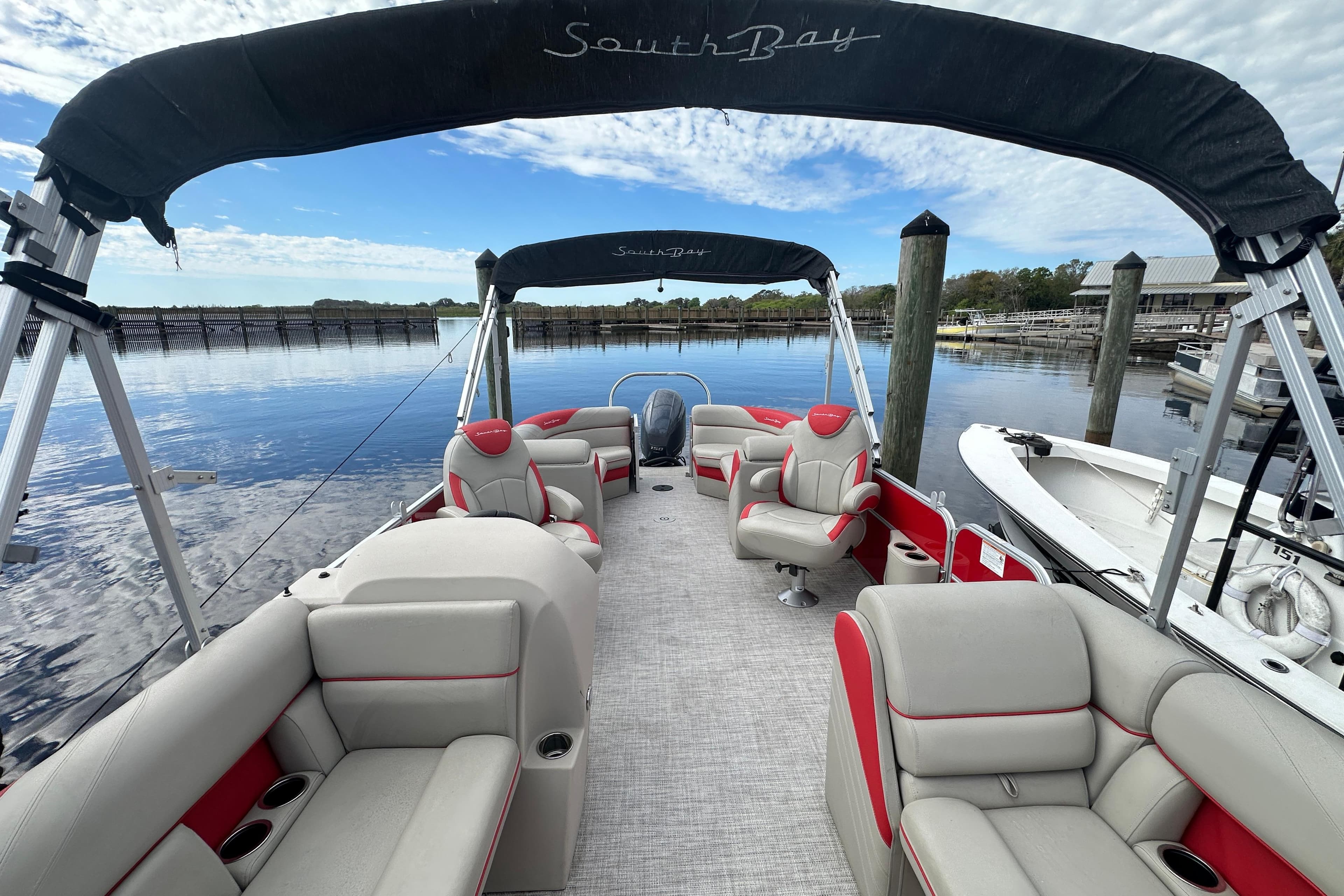 2022 South Bay Pontoons 24 LE Series Tri Hull on calm water, featuring spacious seating.