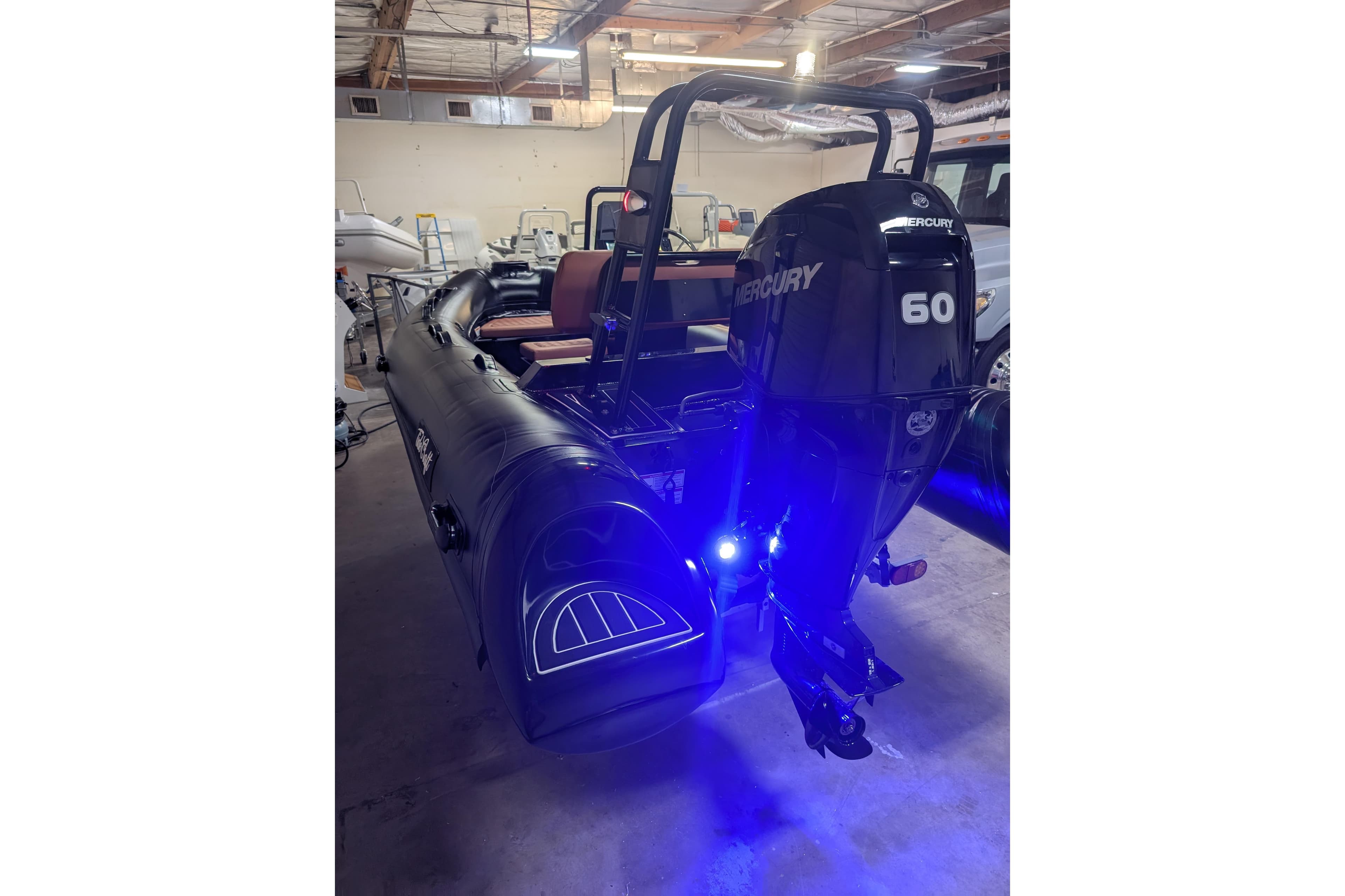 2026 Tide Craft Custom Black & Tan Catalina 13 boat with Mercury 60 engine in a garage.