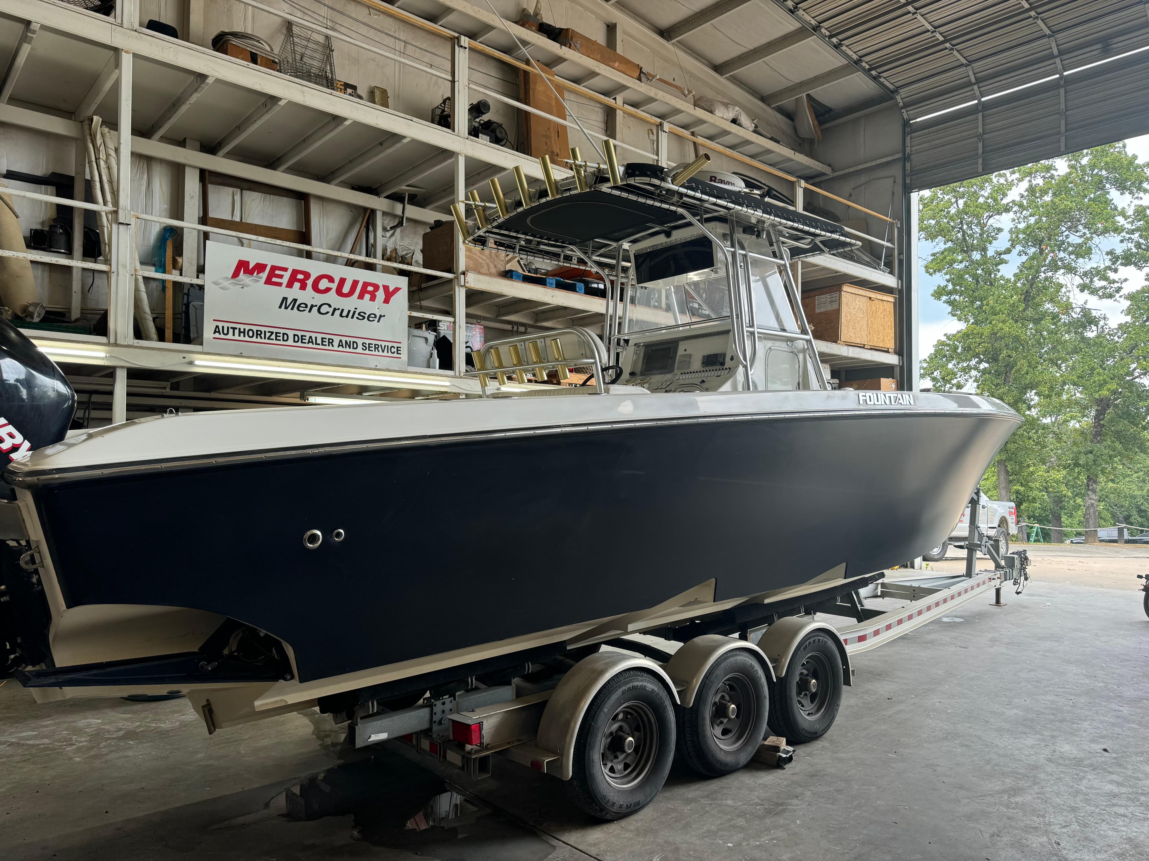 2007 Fountain 32 CC boat on trailer in a garage, Mercury MerCruiser sign visible.