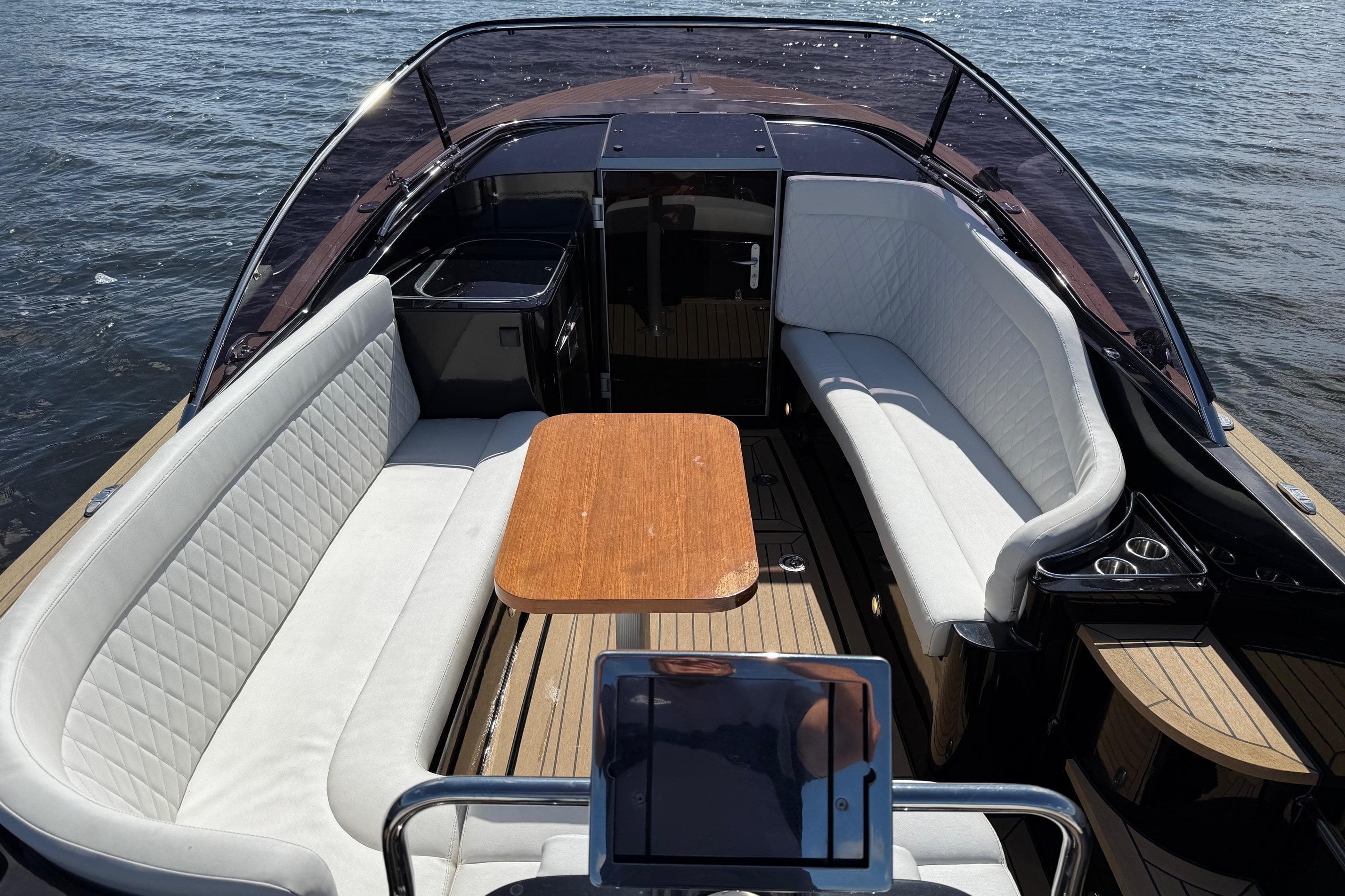 Luxurious 2017 Zarro Maxx 27 boat interior with white seating and wooden table on water.