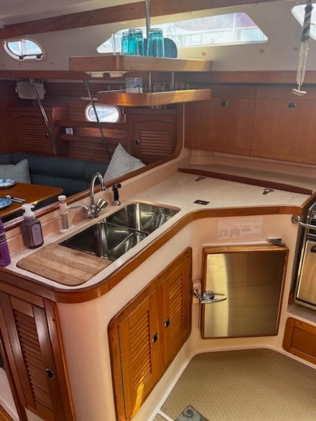 Interior of 2001 Catalina 400 MkII sailboat with wooden cabinetry and modern kitchen amenities.