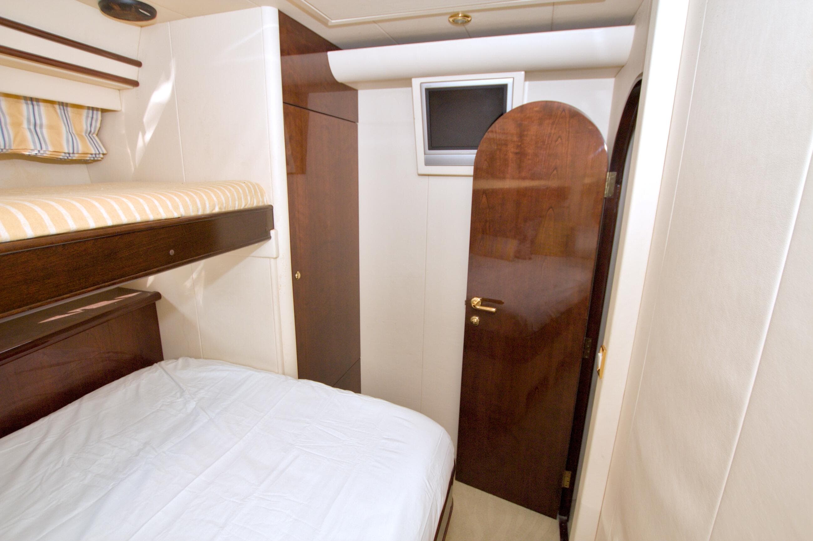 Interior cabin of 2005 Neptunus 62 Flybridge yacht with bunk beds and wooden door.