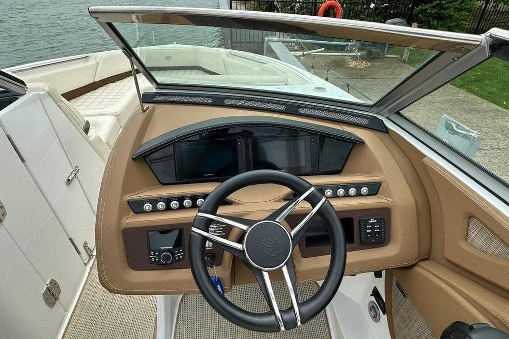 Steering console of a 2020 Cobalt R7 boat with modern controls and beige interior.